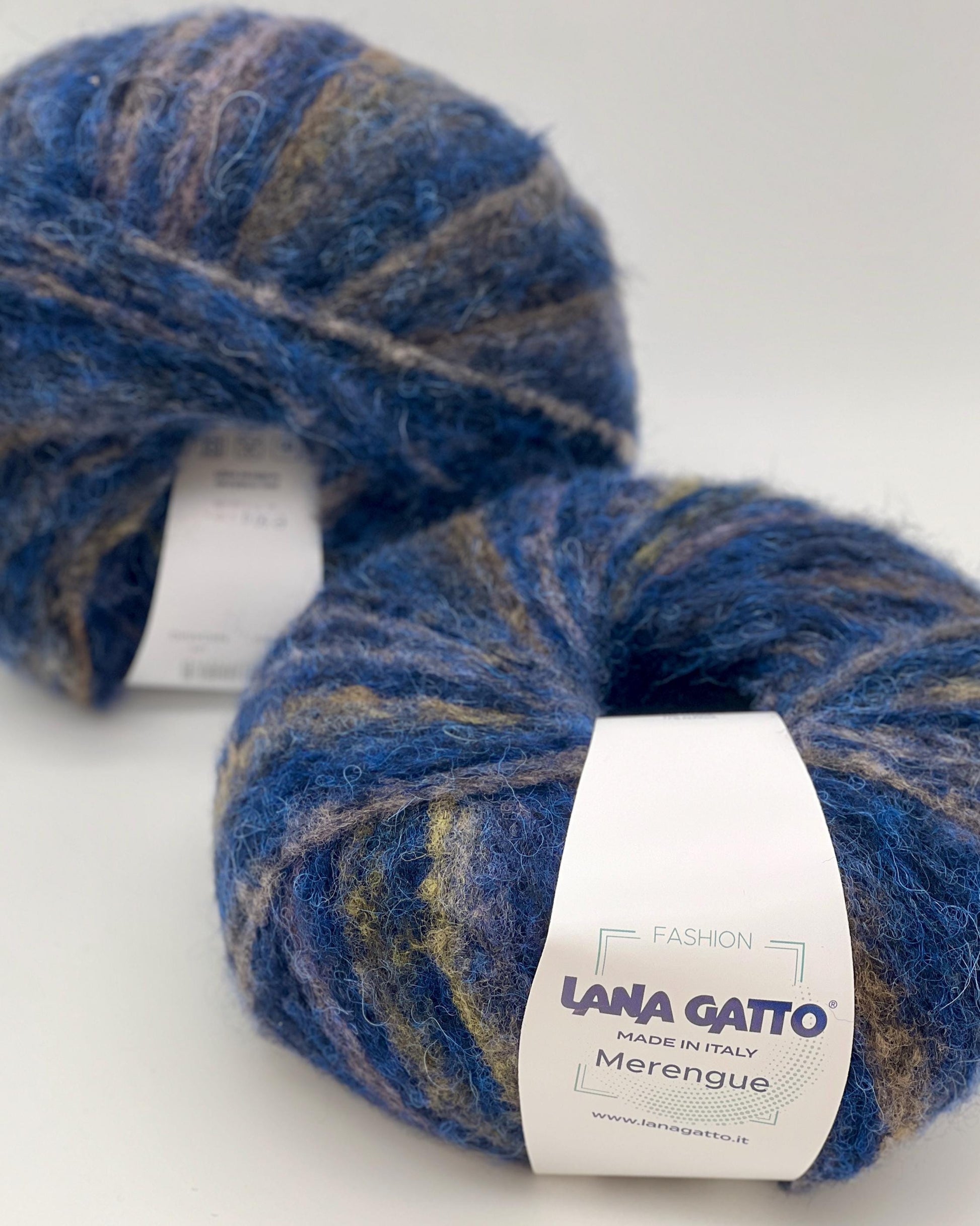 Two skeins of blue yarn with a visible label on a white background