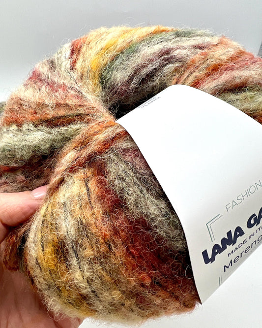 Multicolored skein of yarn with a label on a light gray background