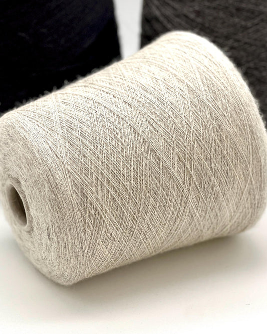 Close-up of a roll of beige yarn on a white background