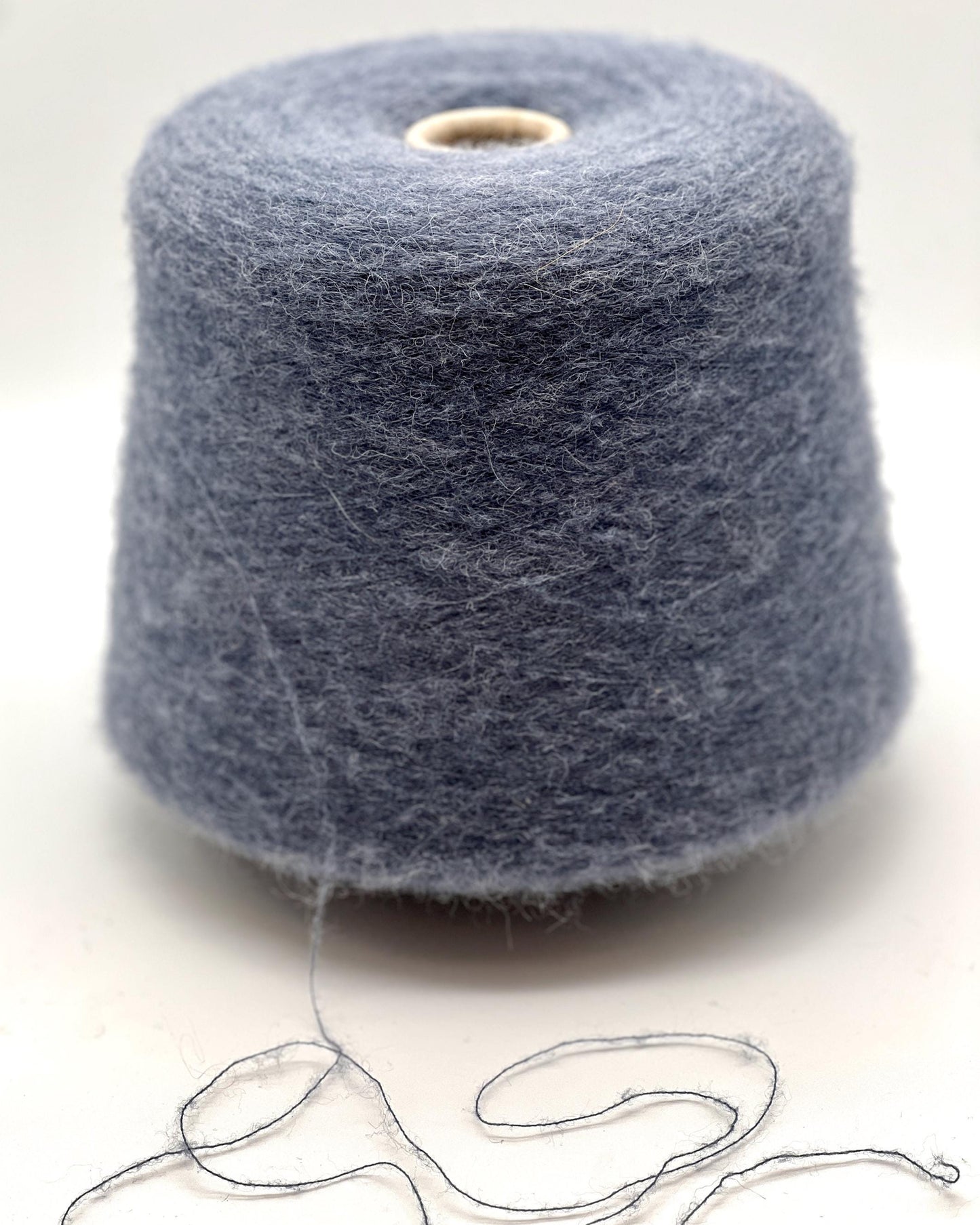 Spool of gray yarn on a white background