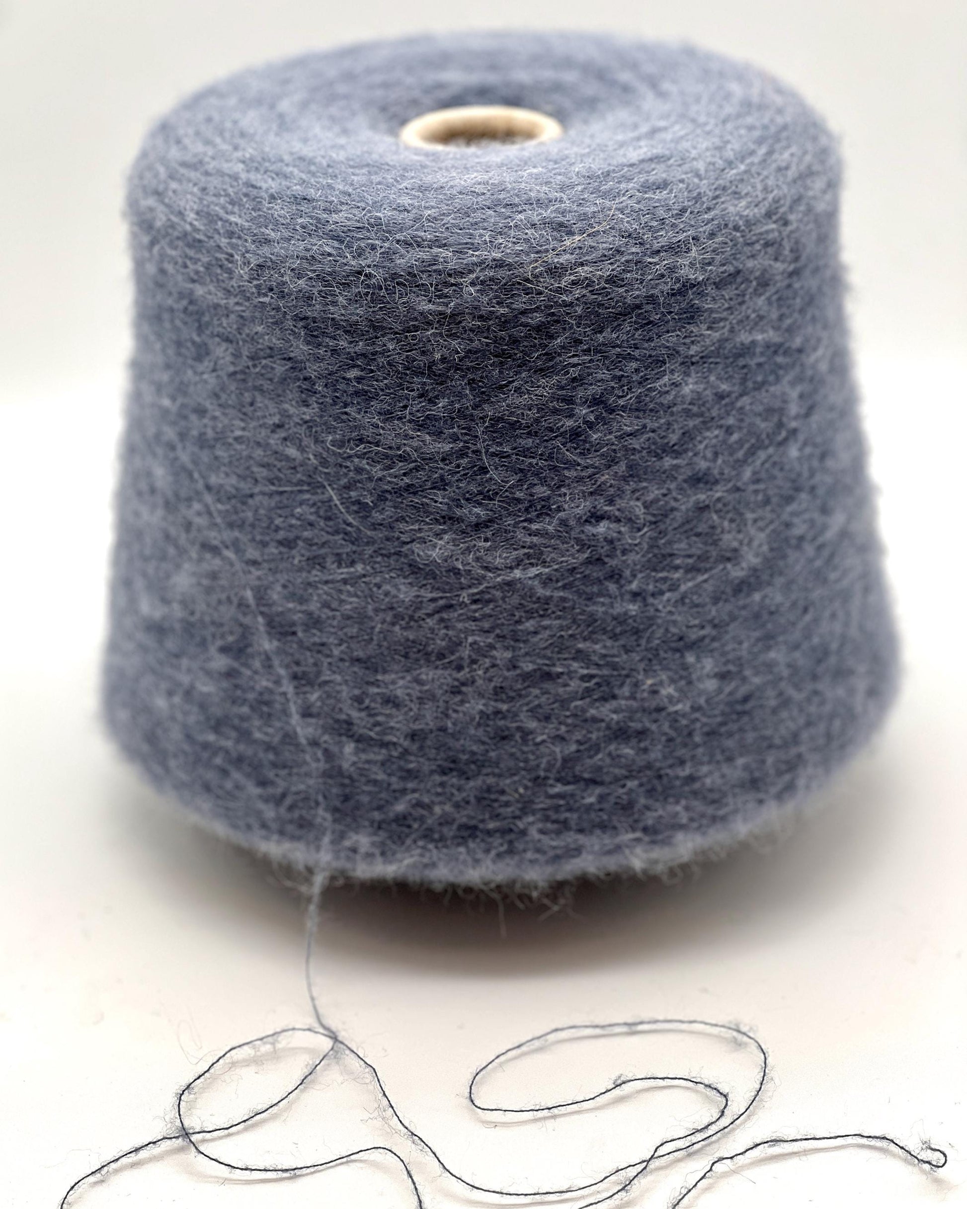 Spool of gray yarn on a white background