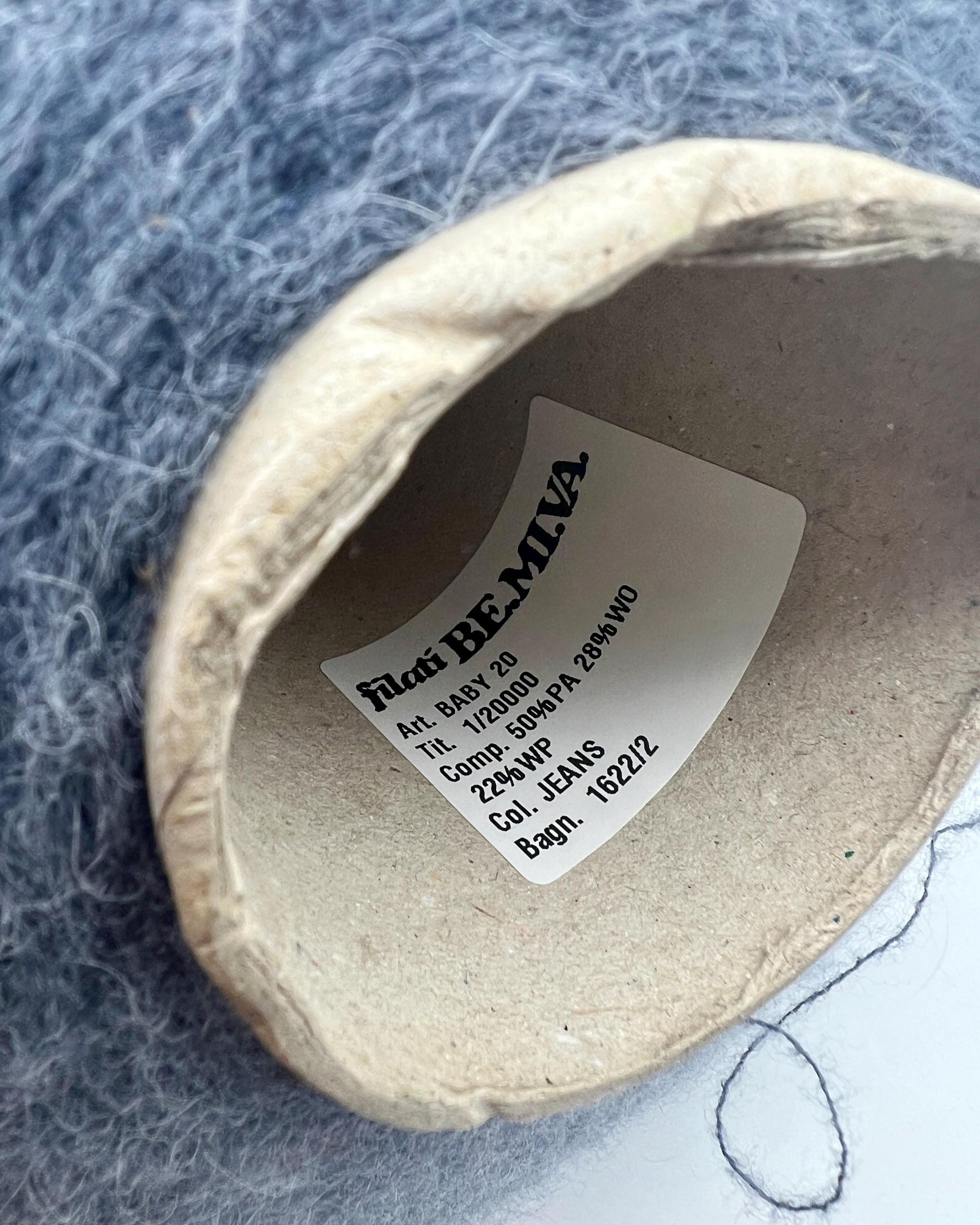 Label inside a beige shoe on a textured gray background
