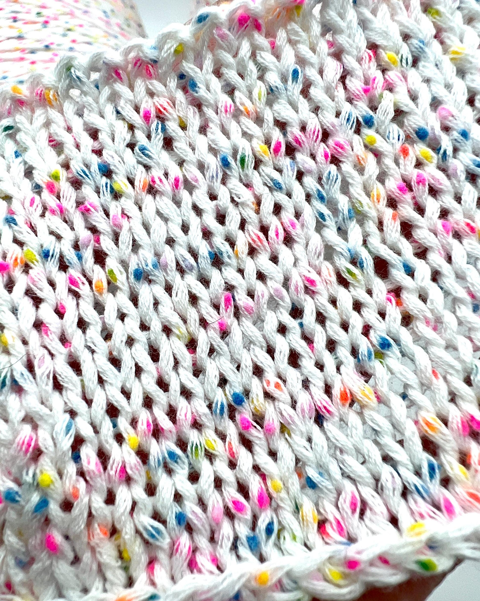 Close-up of a knitted fabric with colorful yarn strands.