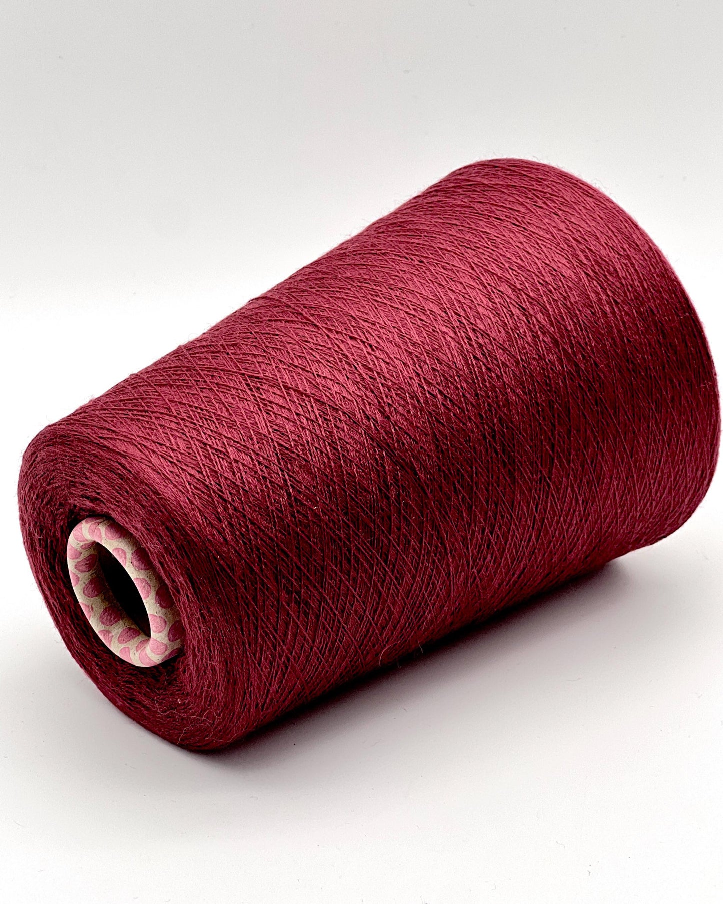 Red spool of yarn on a white background