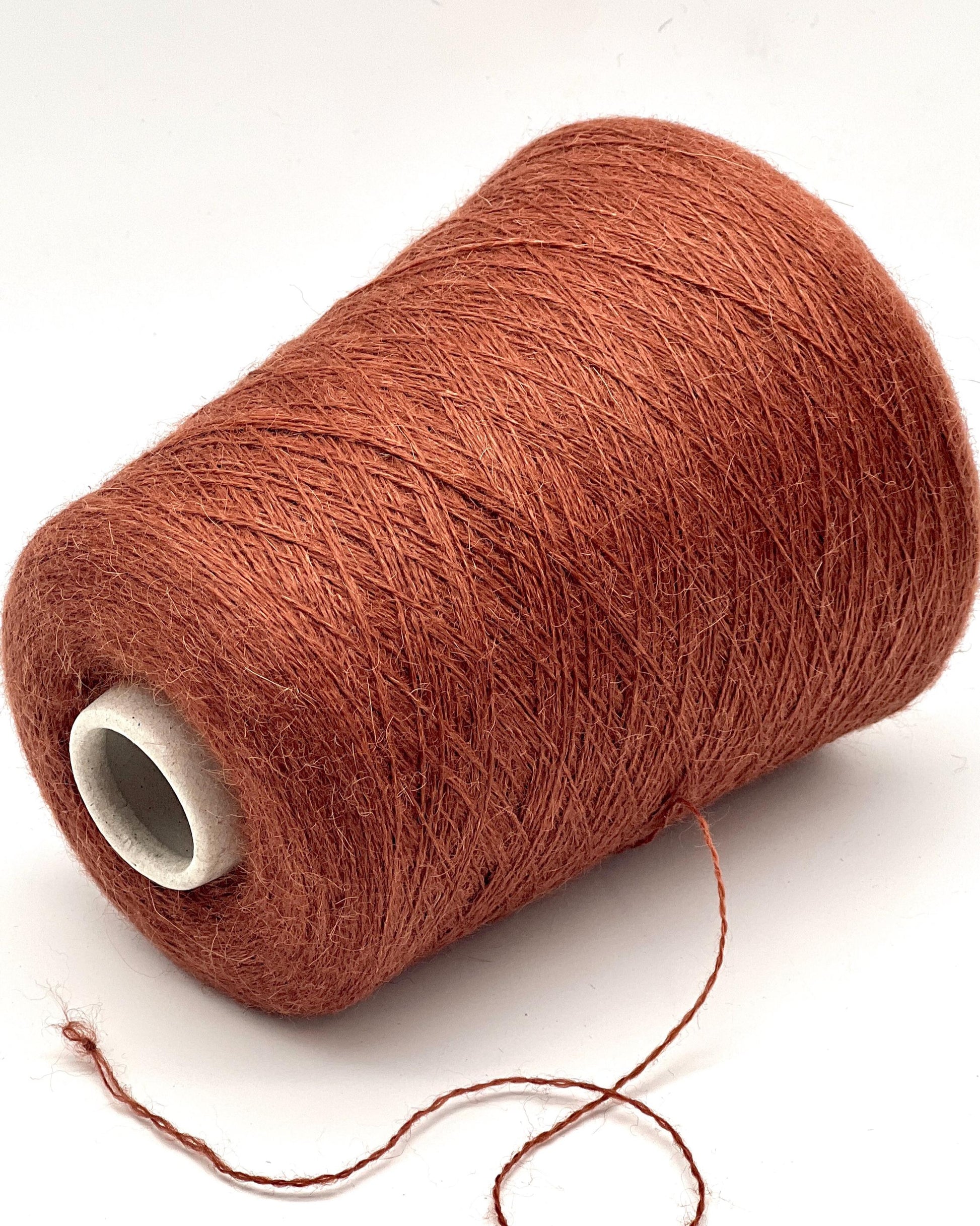 Spool of brown yarn on a white background