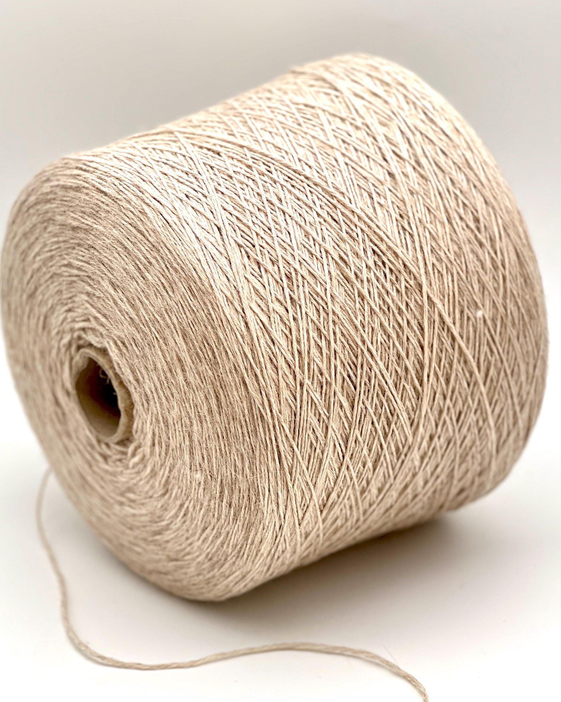 Beige yarn spool on a white background