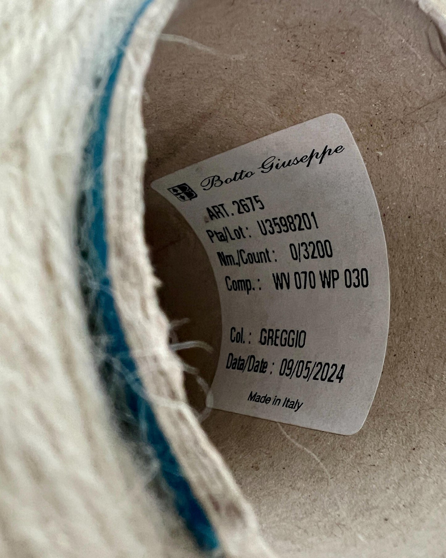 Close-up of a label on a woven product with text and numbers.