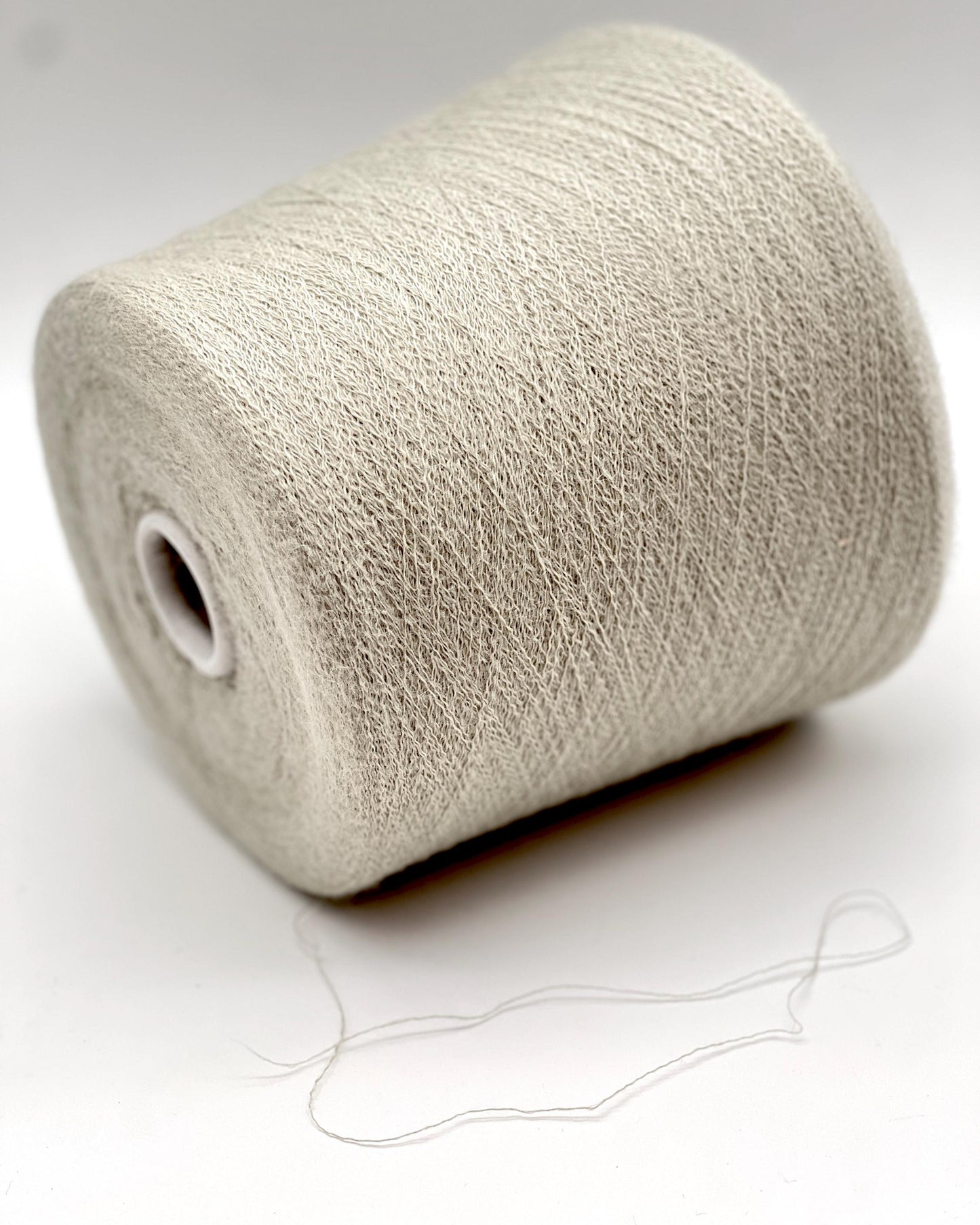 Roll of beige yarn on a white background
