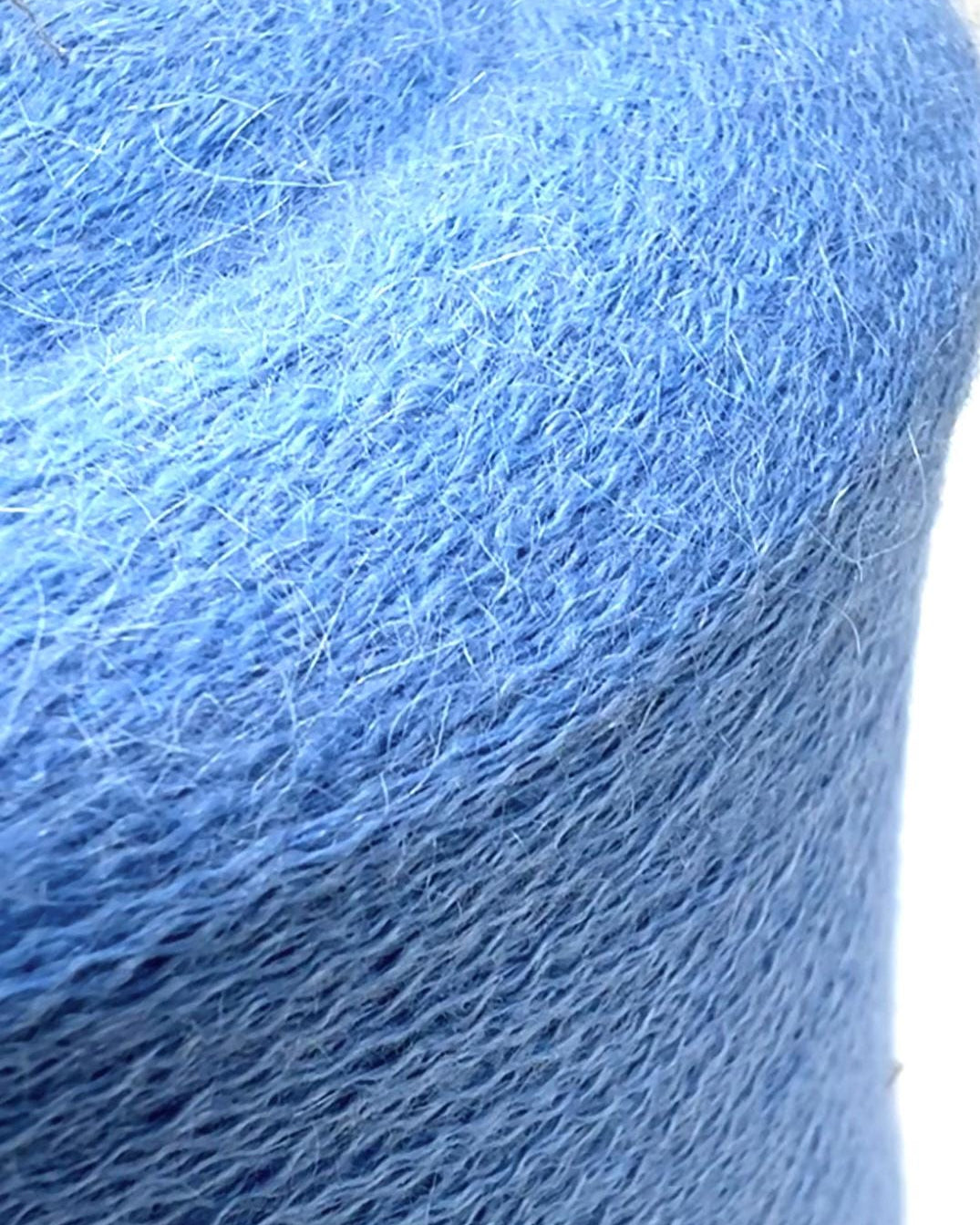 Close-up of a blue skein of yarn on a white background