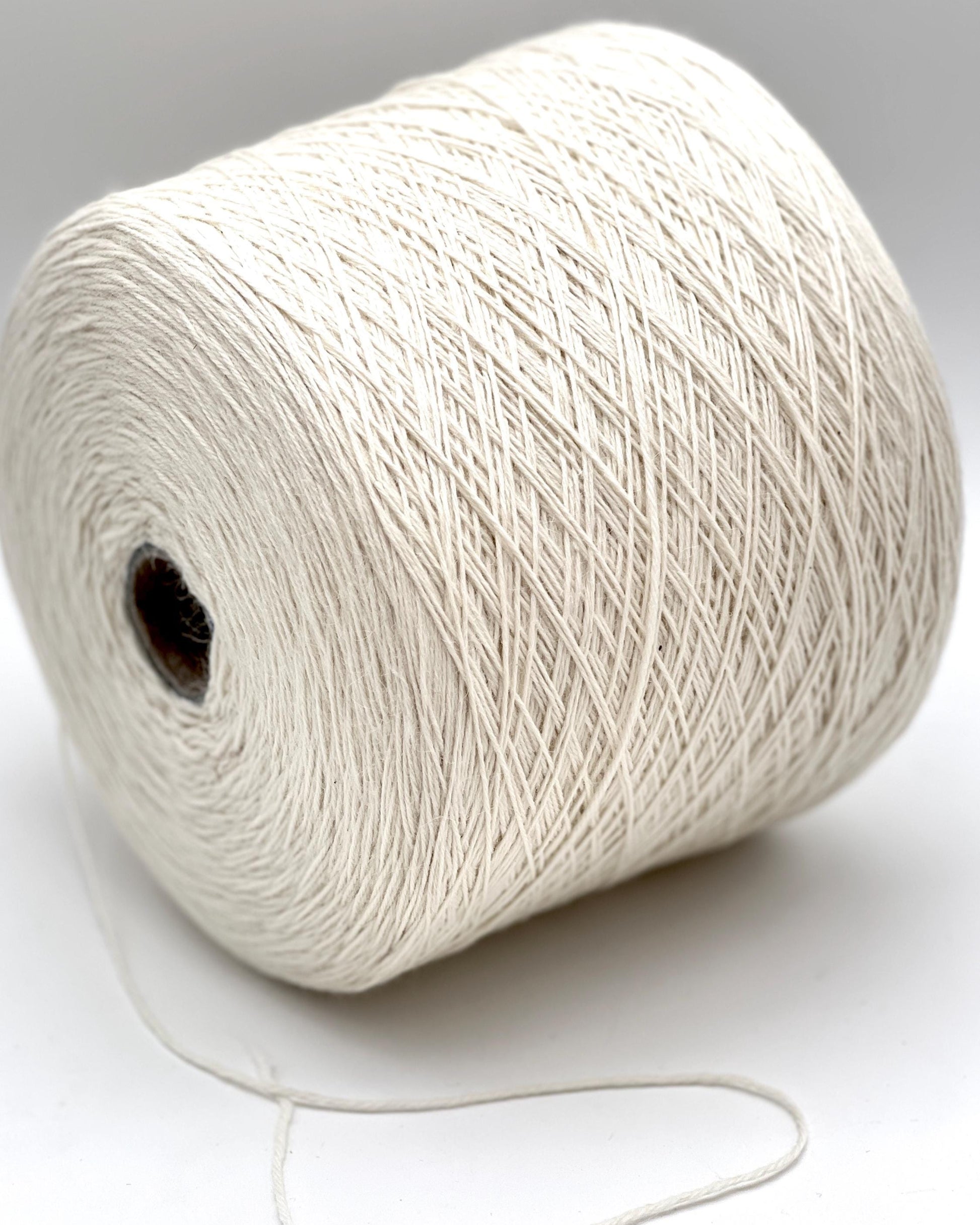 Spool of white yarn on a white background