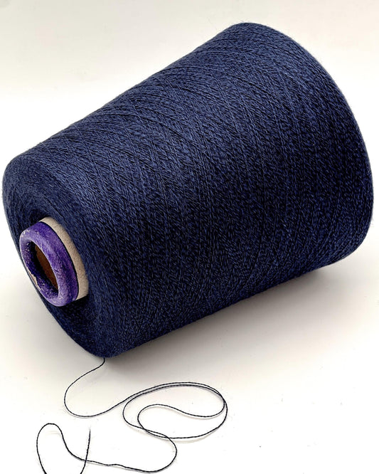 Large spool of dark blue thread with a small amount of thread on a white background