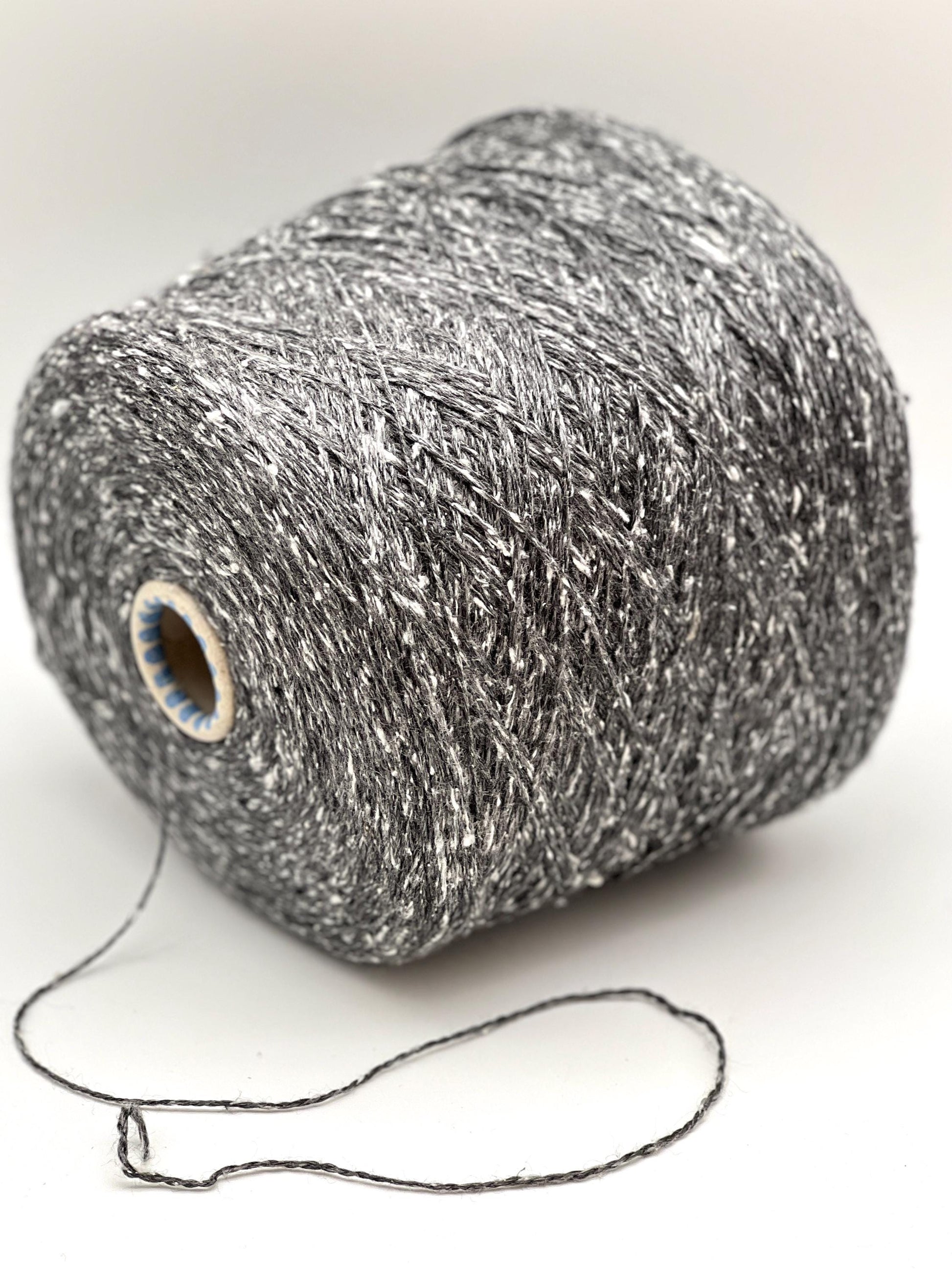 Spool of metallic yarn on a white background