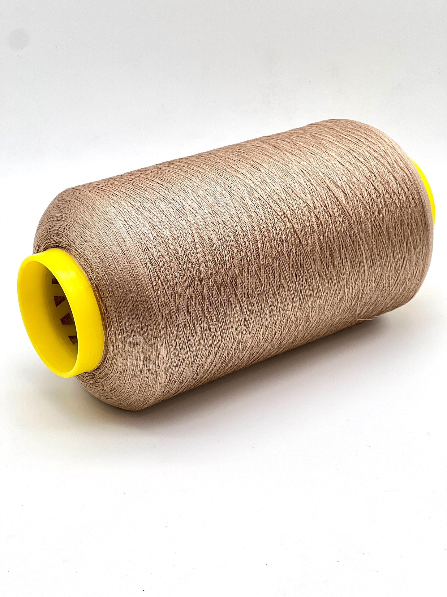 Spool of brown thread with a yellow core on a white background