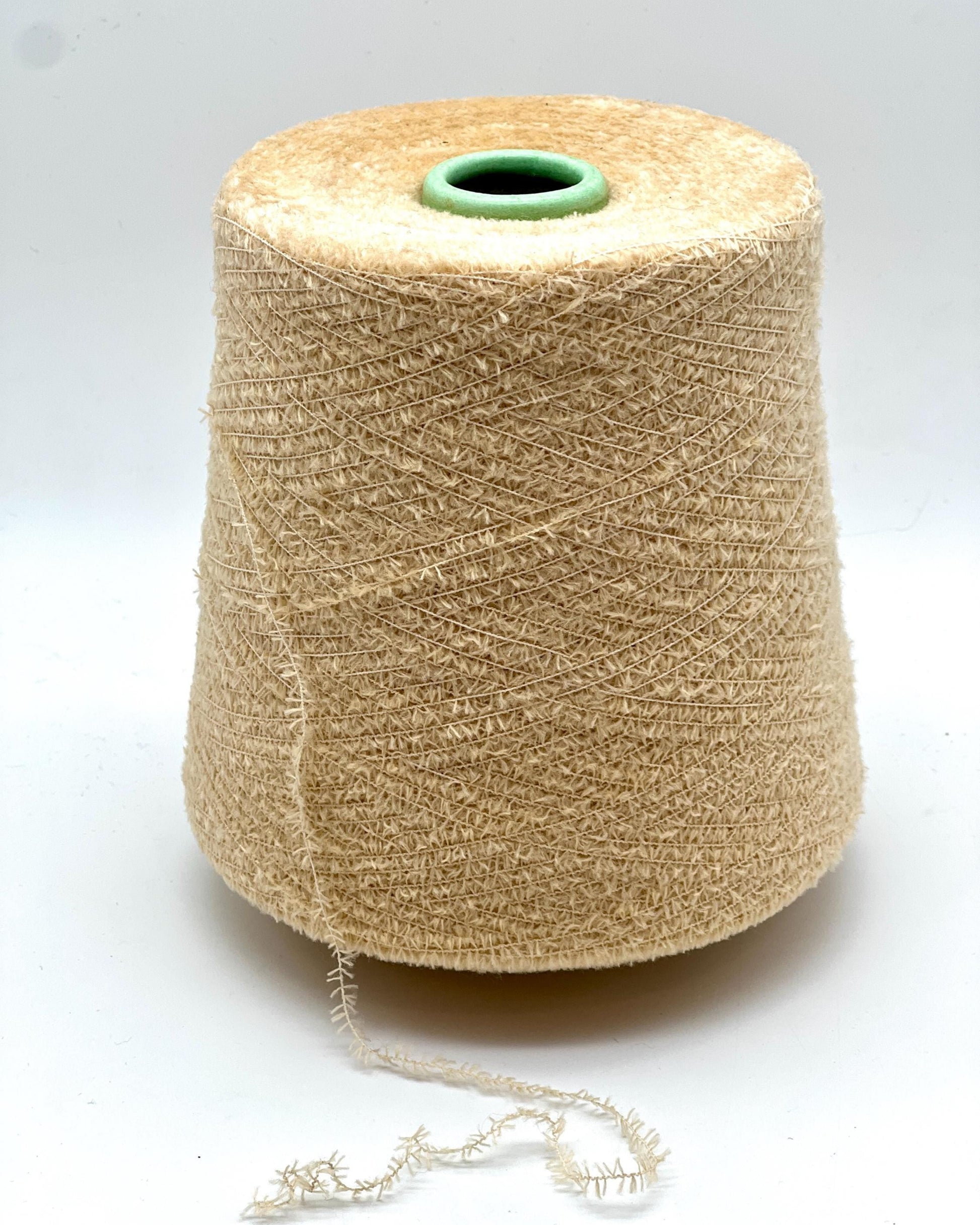 Spool of beige yarn on a white background