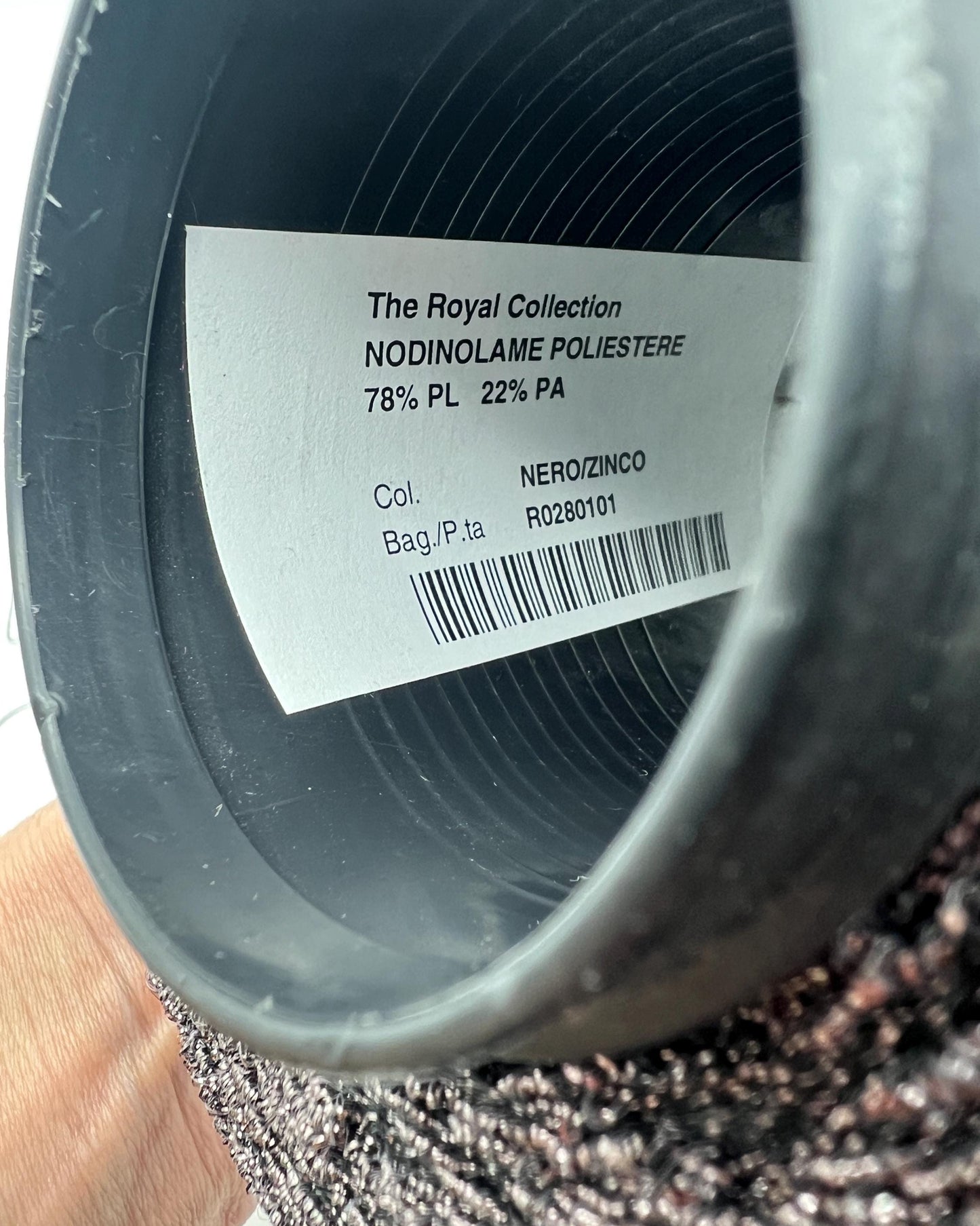 Close-up of a spool of thread with a label on a white background