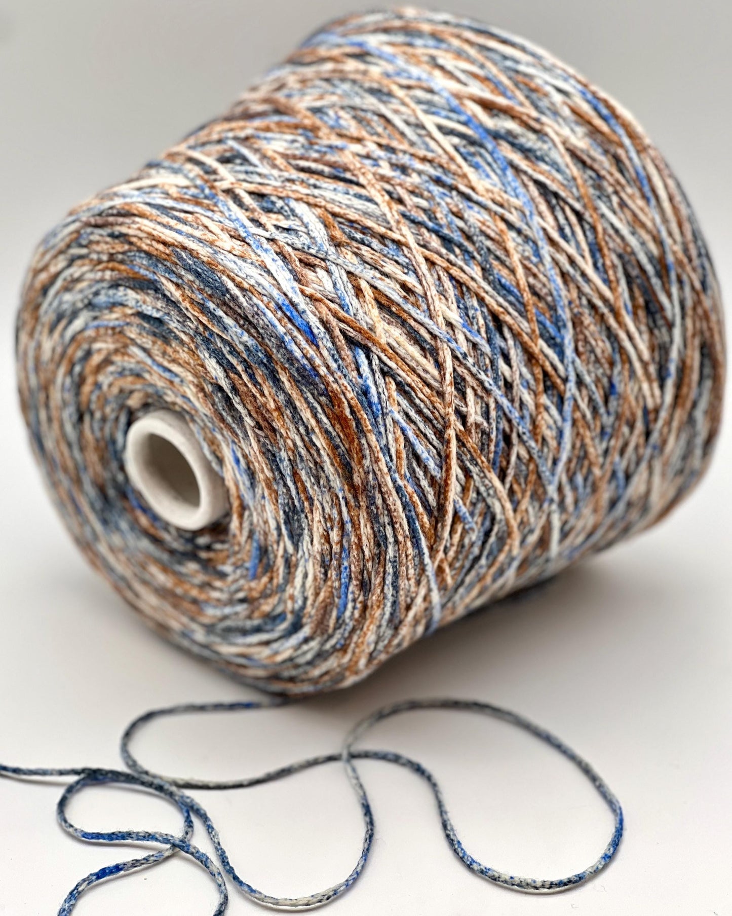 Spool of multicolored yarn on a white background