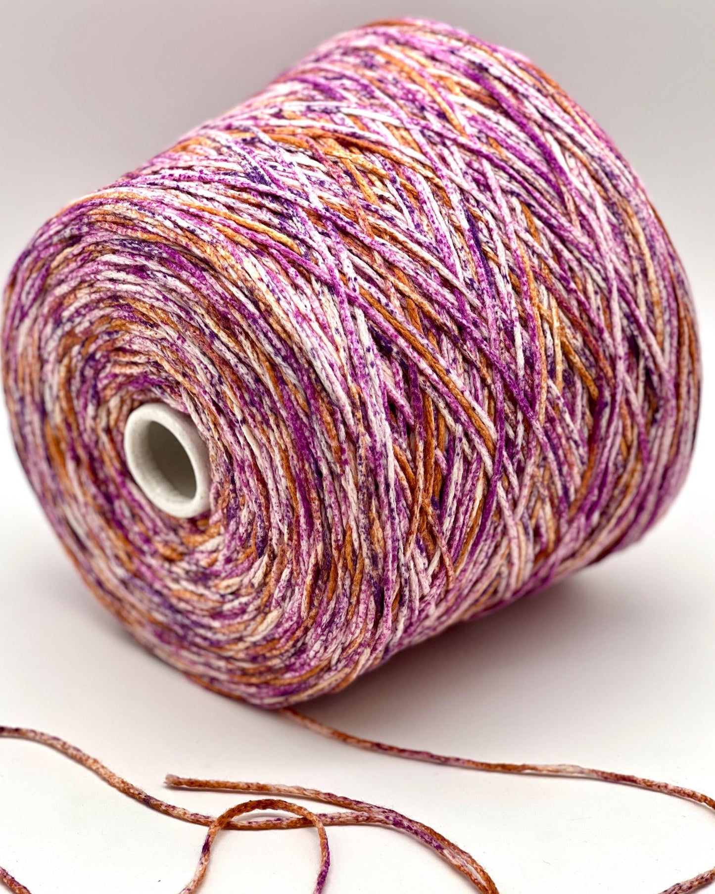 Spool of multicolored yarn on a white background