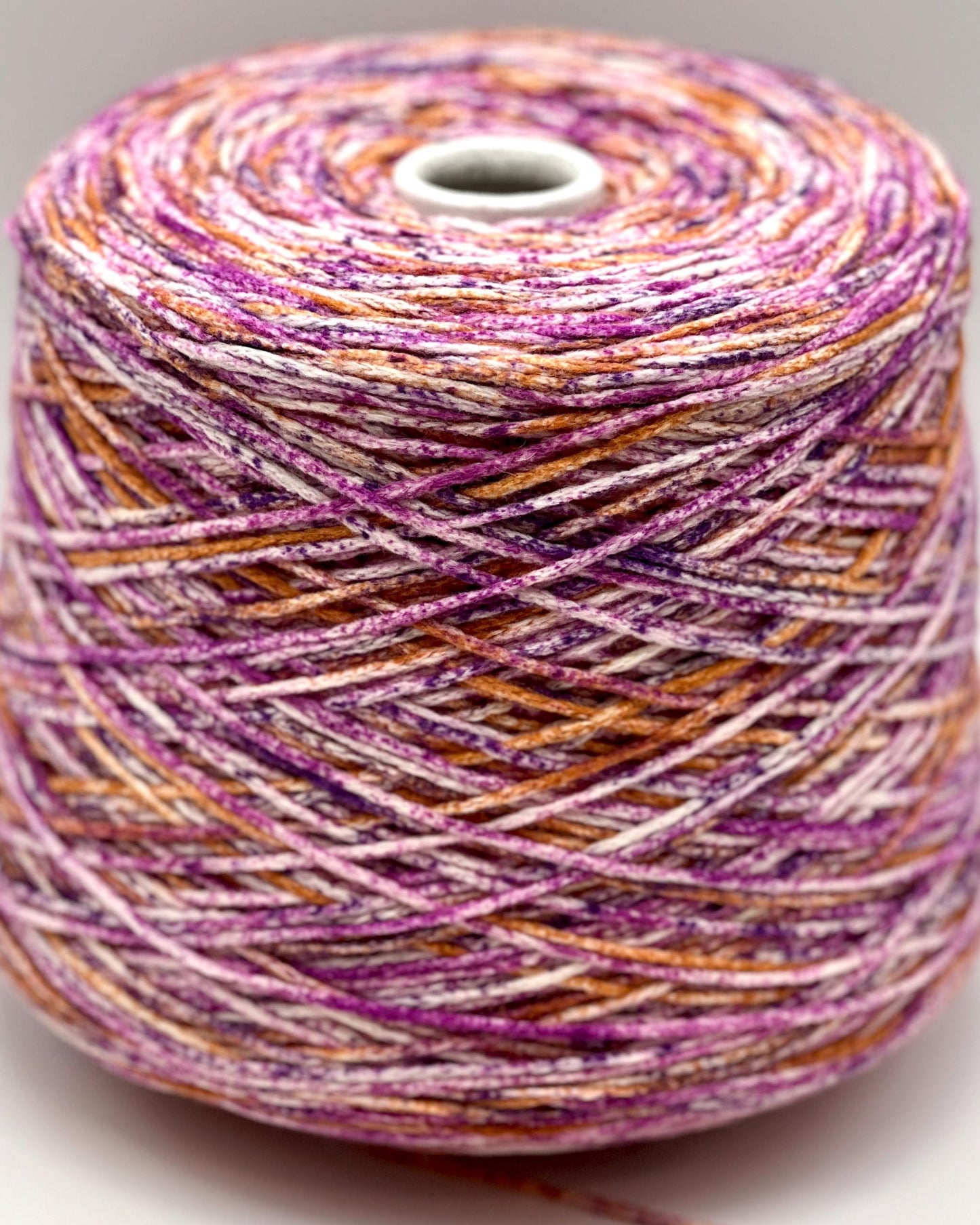 Spool of multicolored yarn on a white background
