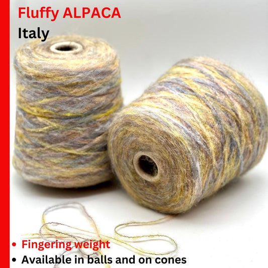 Two spools of Fluffy Alpaca yarn from Italy on a white background with text about weight and availability.