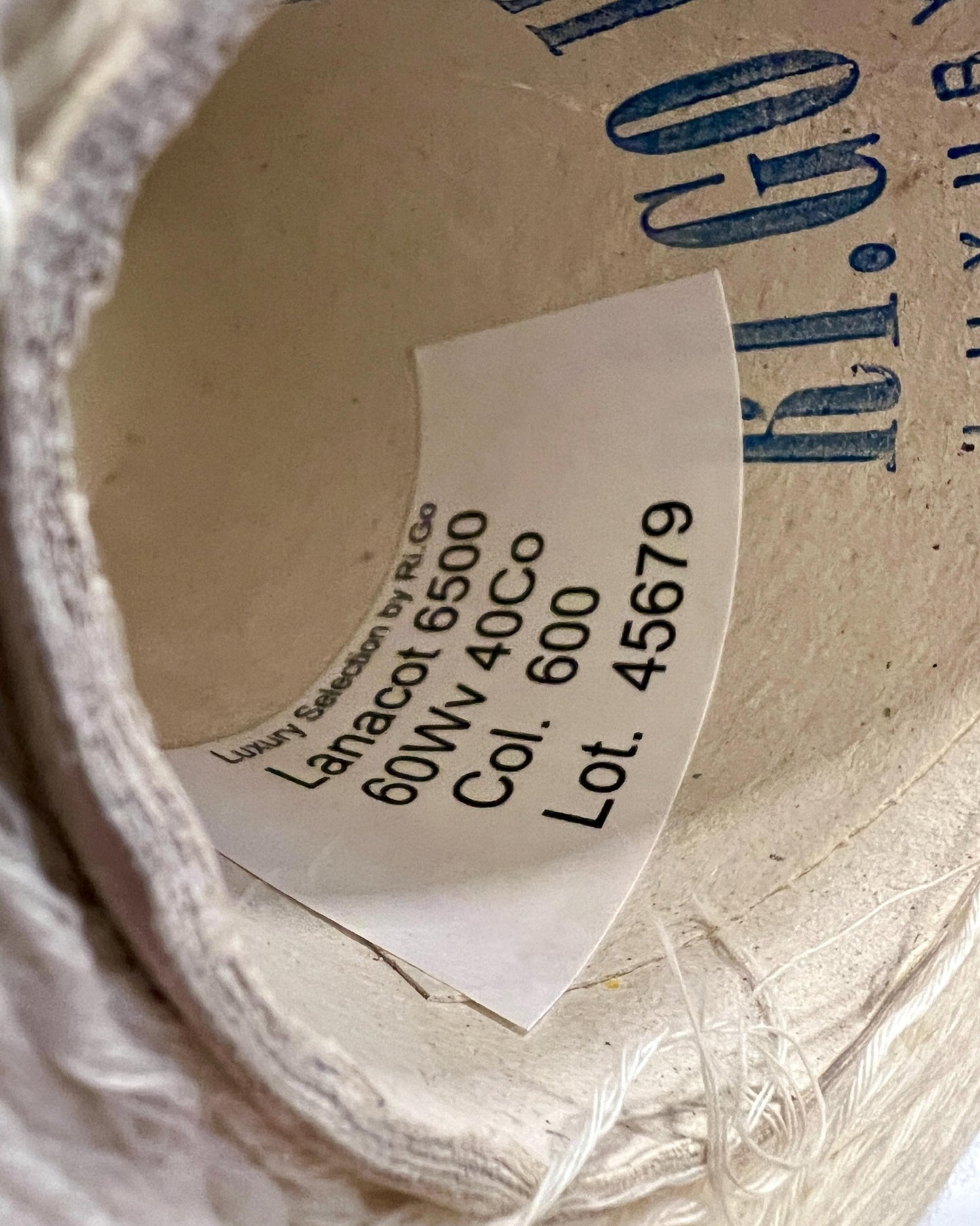 Close-up of a label on a spool of thread with text and numbers.