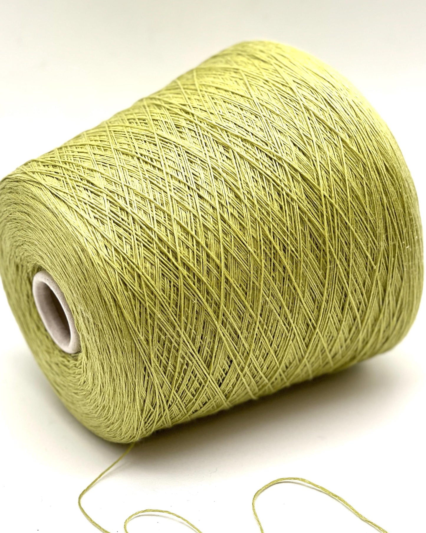 Spool of green yarn on a white background