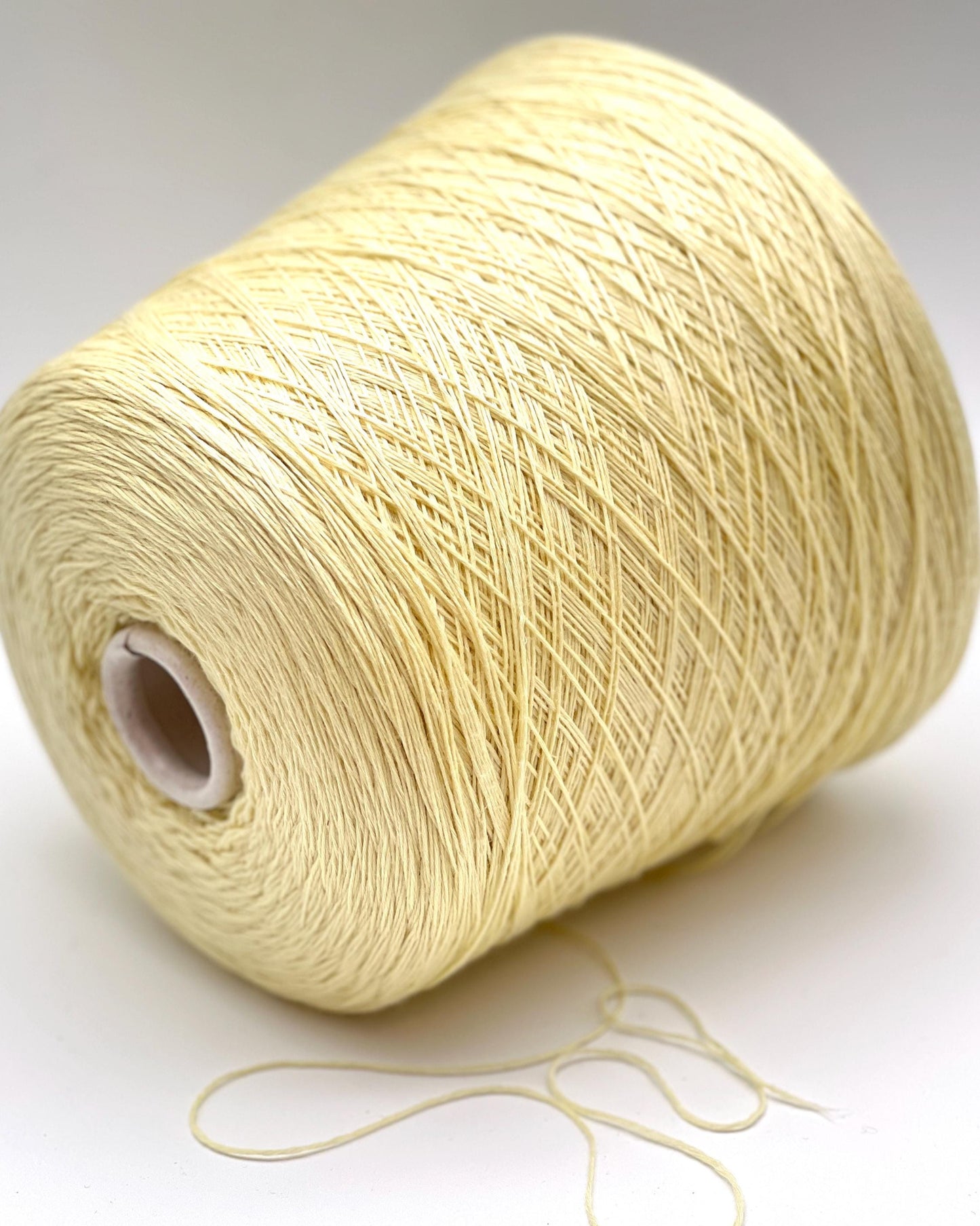 Spool of beige thread on a white background