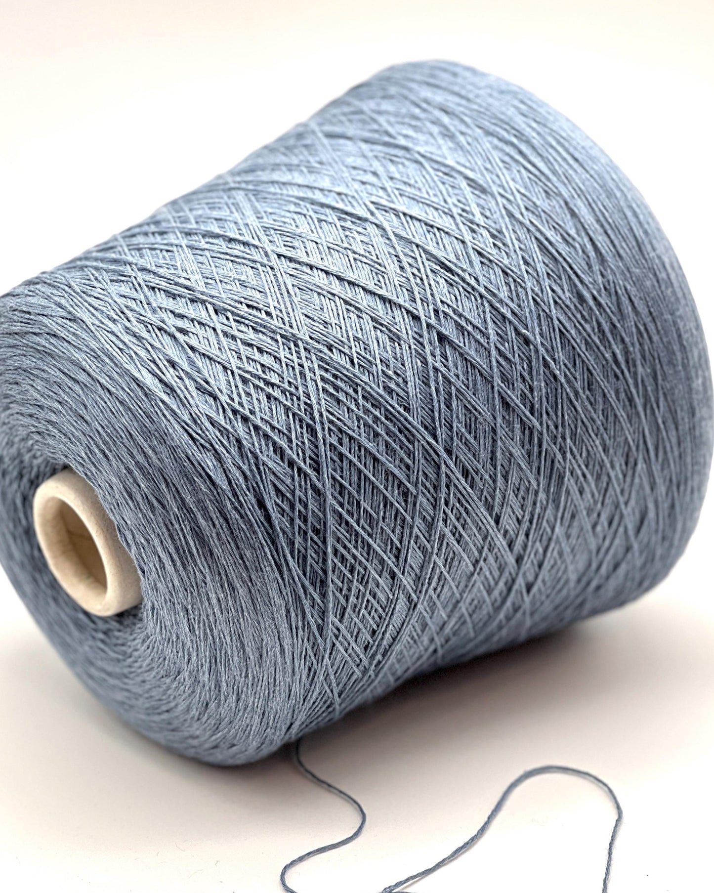 Spool of blue yarn on a light background