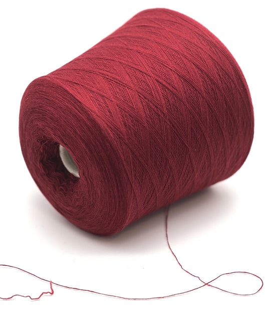 A luxurious cone of RiGo Trebisonda lace-weight yarn in deep Bordeaux #1428, showcasing the refined 30% Cashmere and 70% Extrafine Merino blend. The collection highlights the incredible 1500m yardage and buttery soft Italian texture perfect for ultra-light knitwear. Available at iDOKNiT.com.