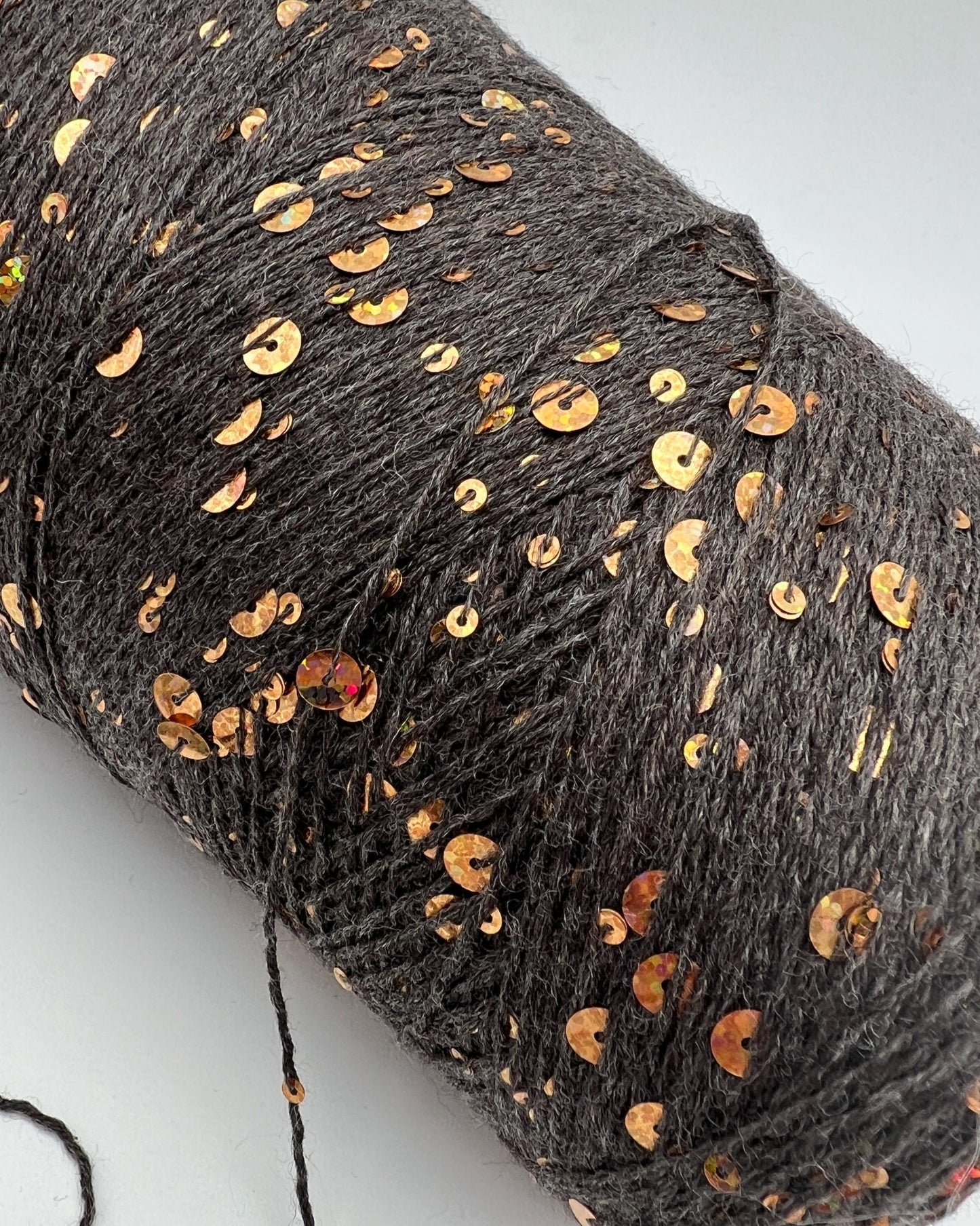 Gray yarn with gold sequins on a white background