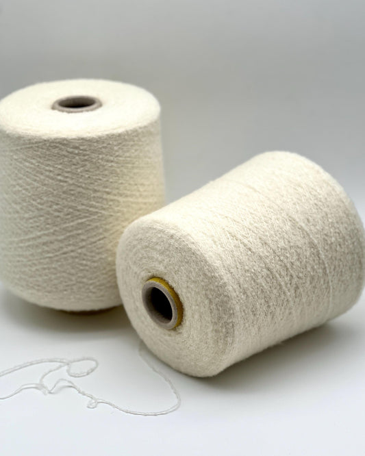 Fluffy boucle merino yarn HAIR WISH Italian lace yarn
soft halo micro boucle yarn cone in milk white color
luxury fluffy merino companion yarn for knitting and weaving
airy Italian lace weight boucle yarn close up texture
soft boucle halo yarn for sweaters shawls and couture knitting