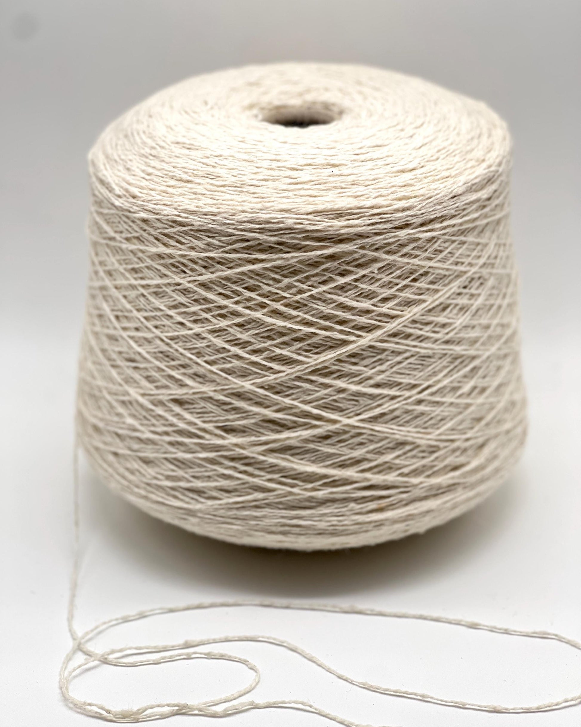 Spool of beige thread on a white background