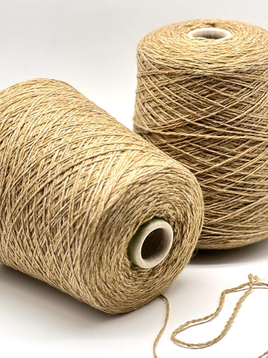 Two spools of beige thread on a white background