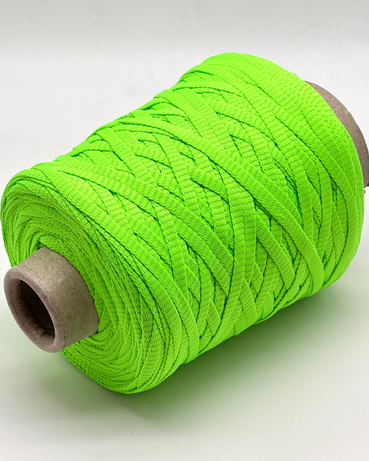 Spool of bright green yarn on a white background