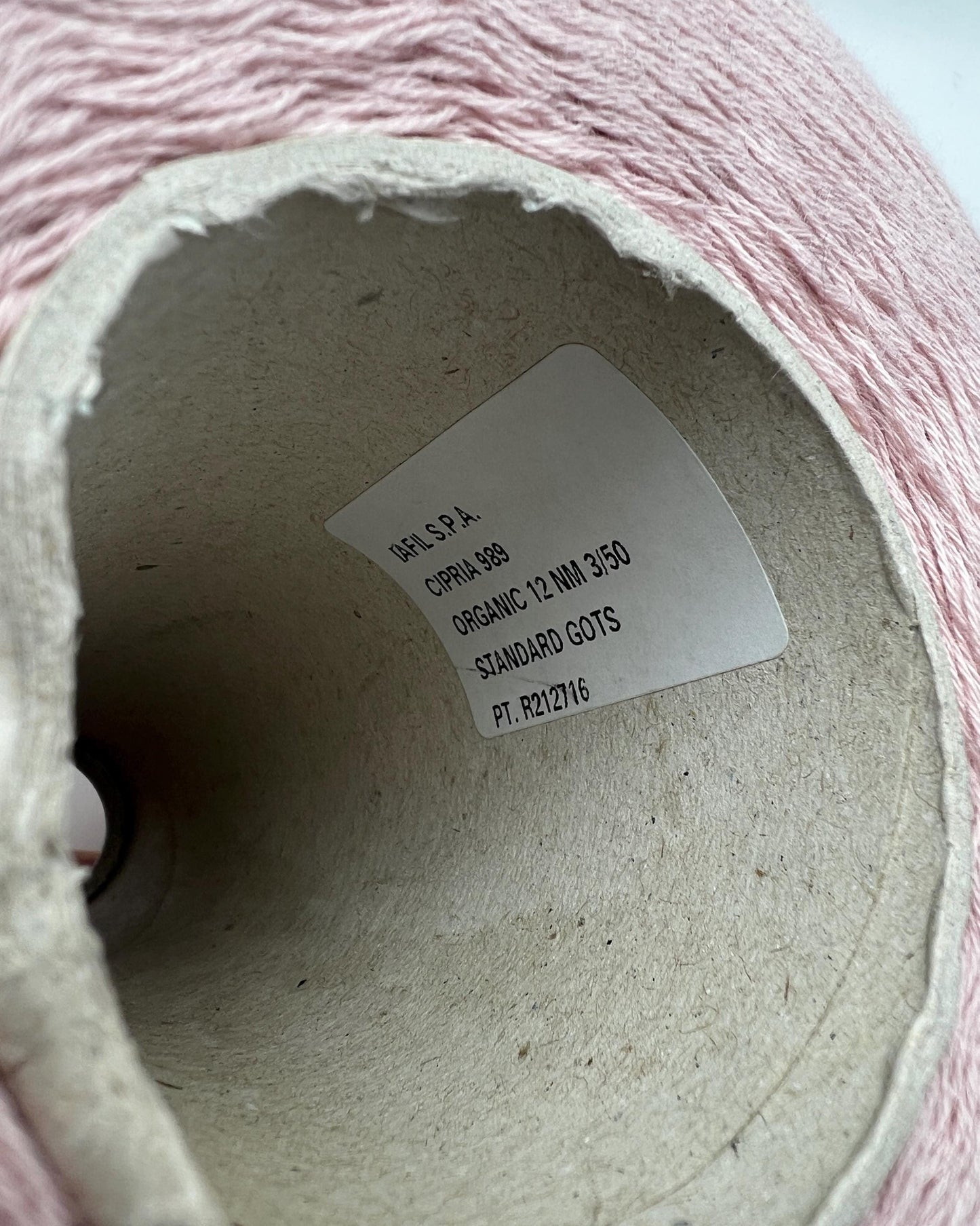 Close-up of a roll of pink yarn with a label inside