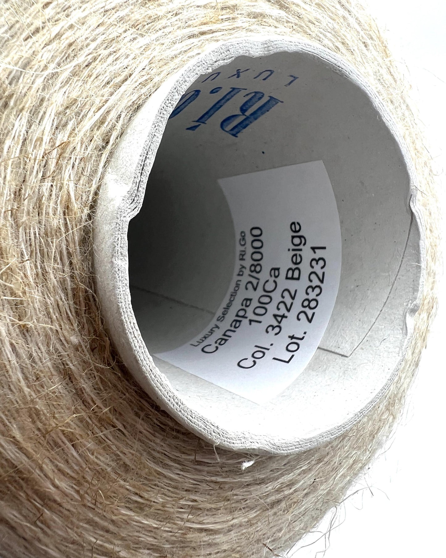 Spool of beige thread with a label on a white background