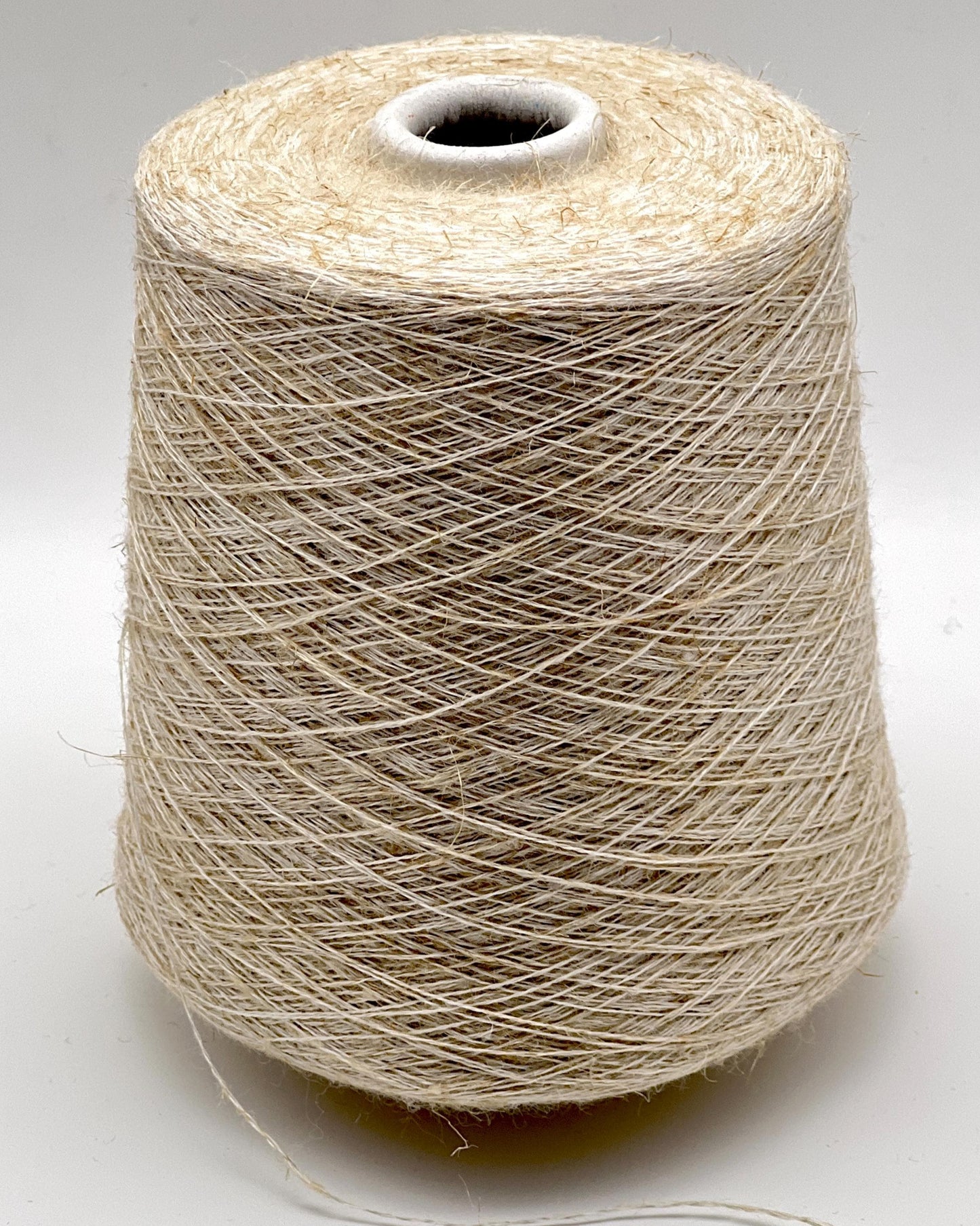Spool of beige thread on a white background