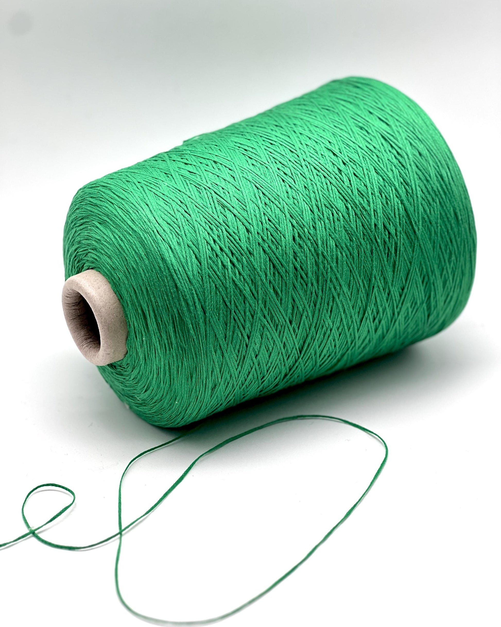 Spool of green thread on a white background