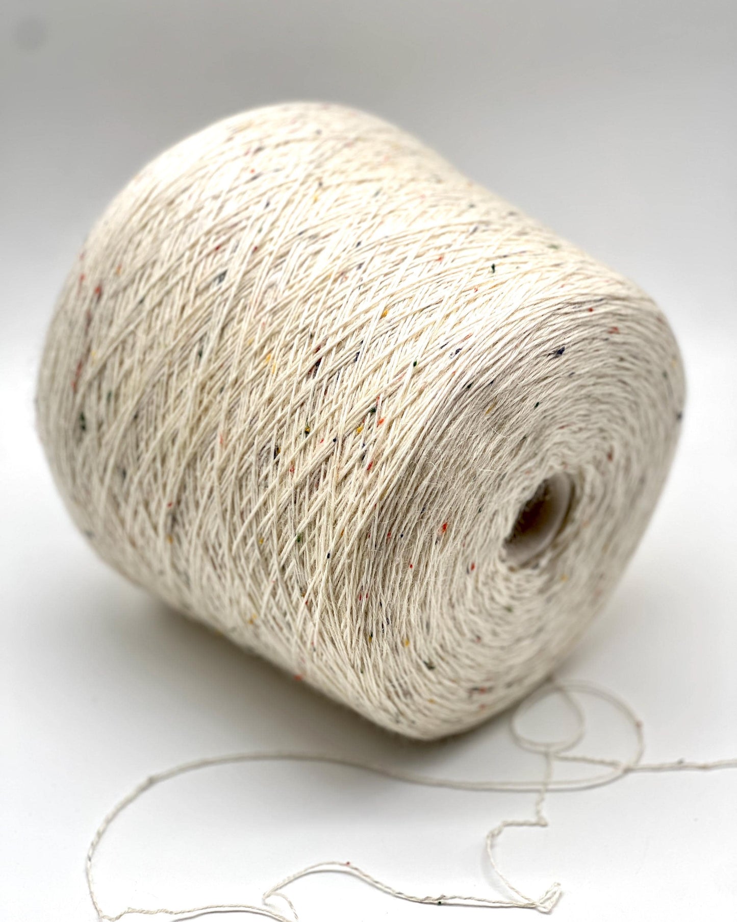 Spool of beige yarn on a white background