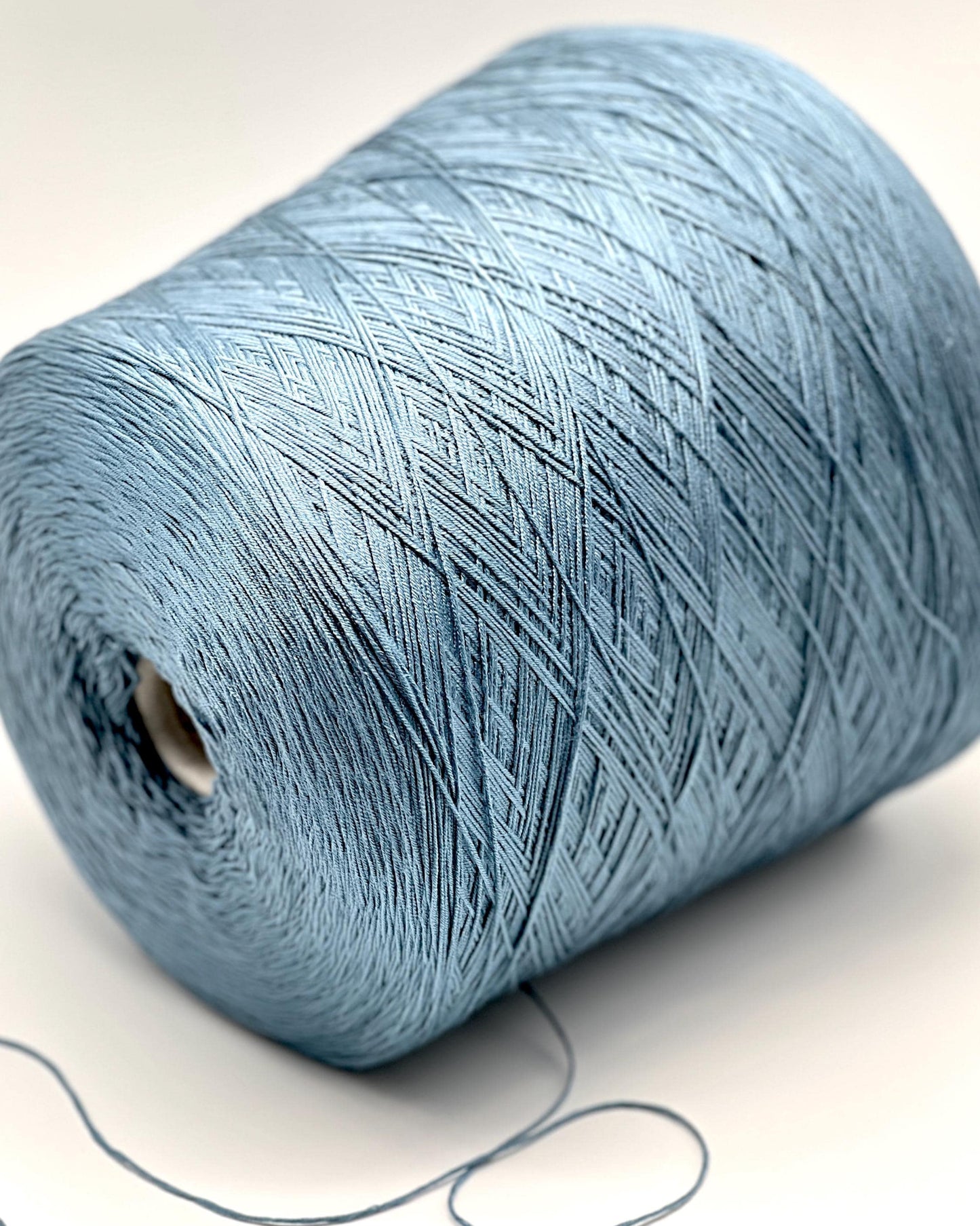 Close-up of a blue spool of yarn on a white background