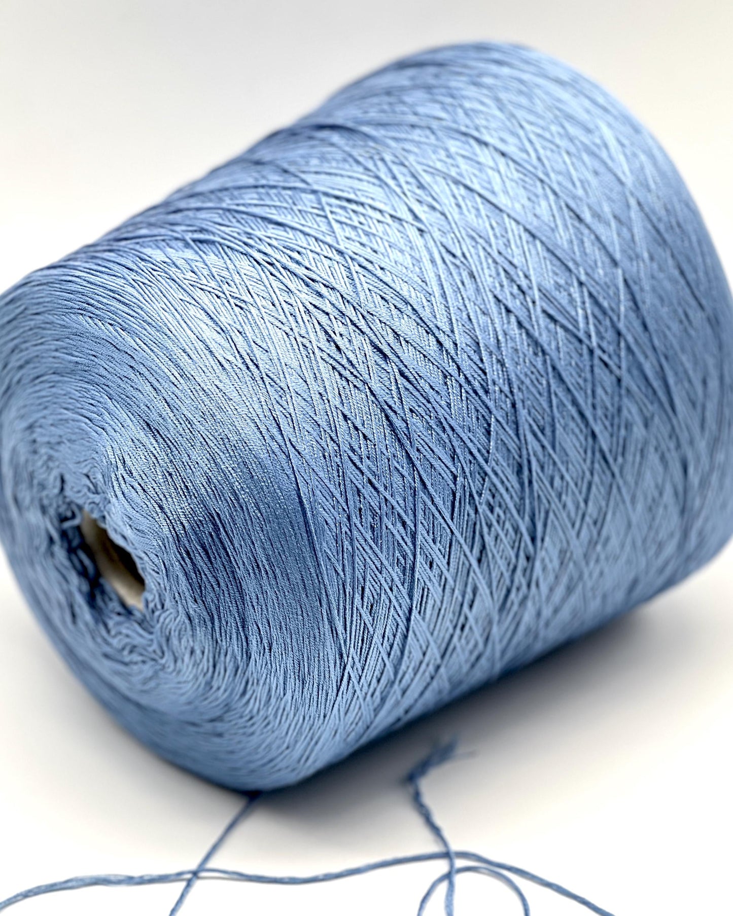 Blue spool of yarn on a white background