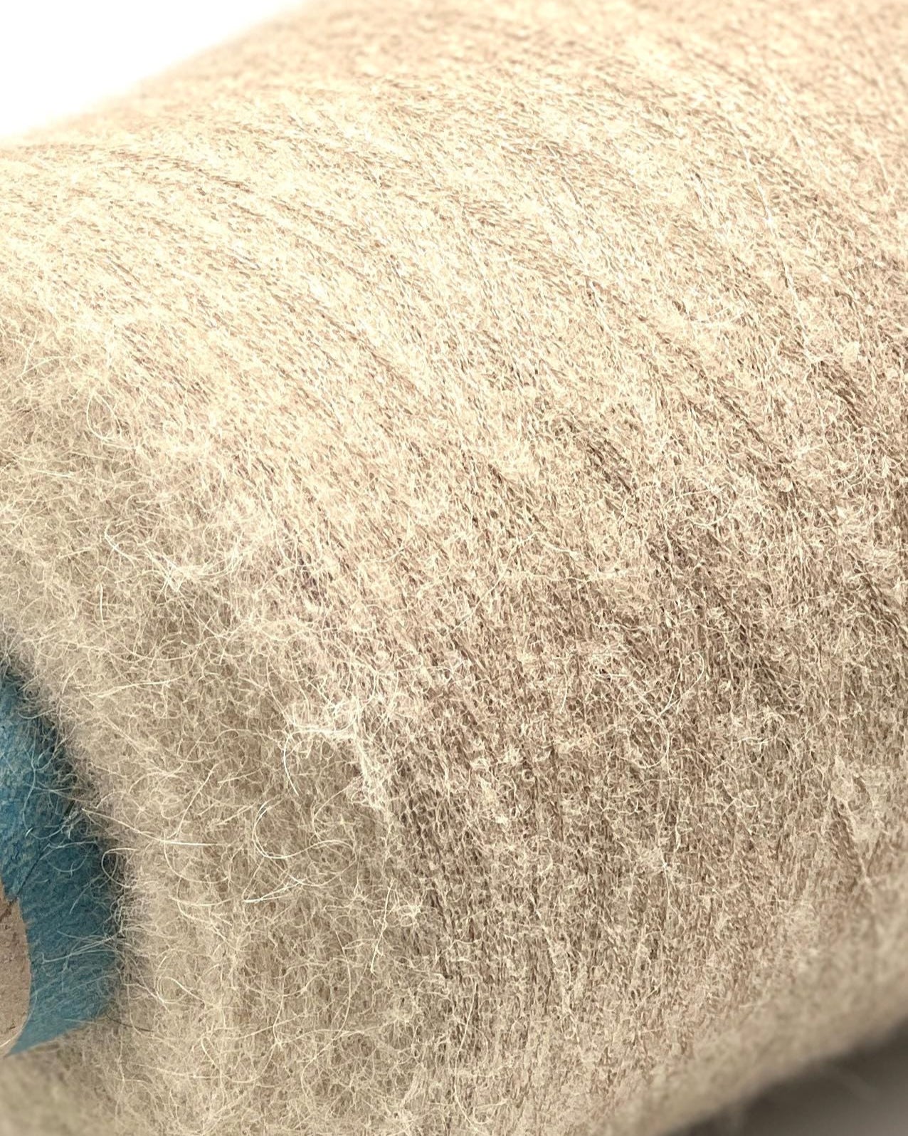Close-up of a roll of beige fabric with a textured surface.
