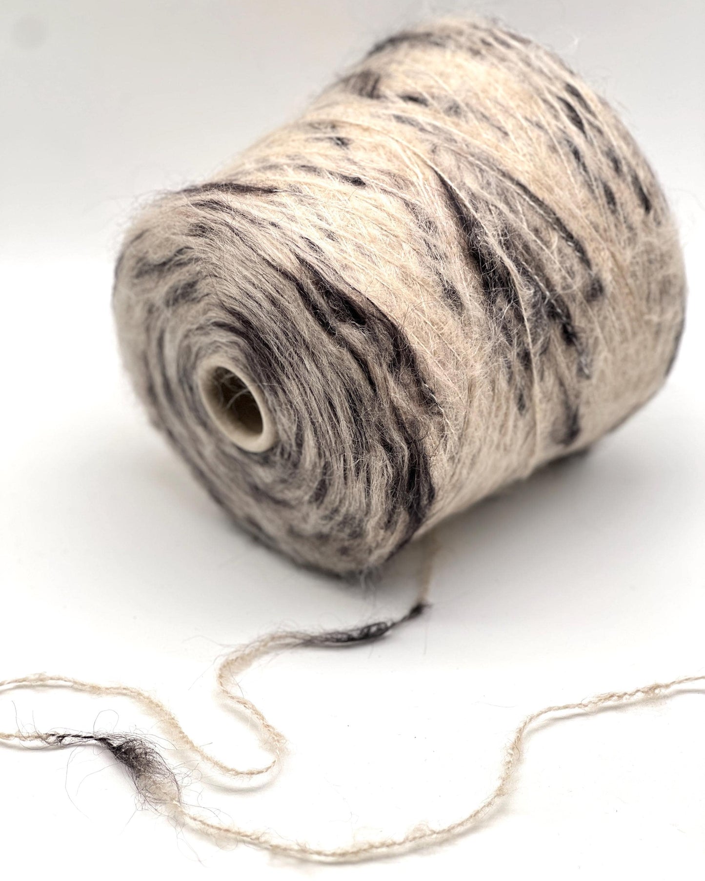 Spool of yarn with a marbled pattern on a white background