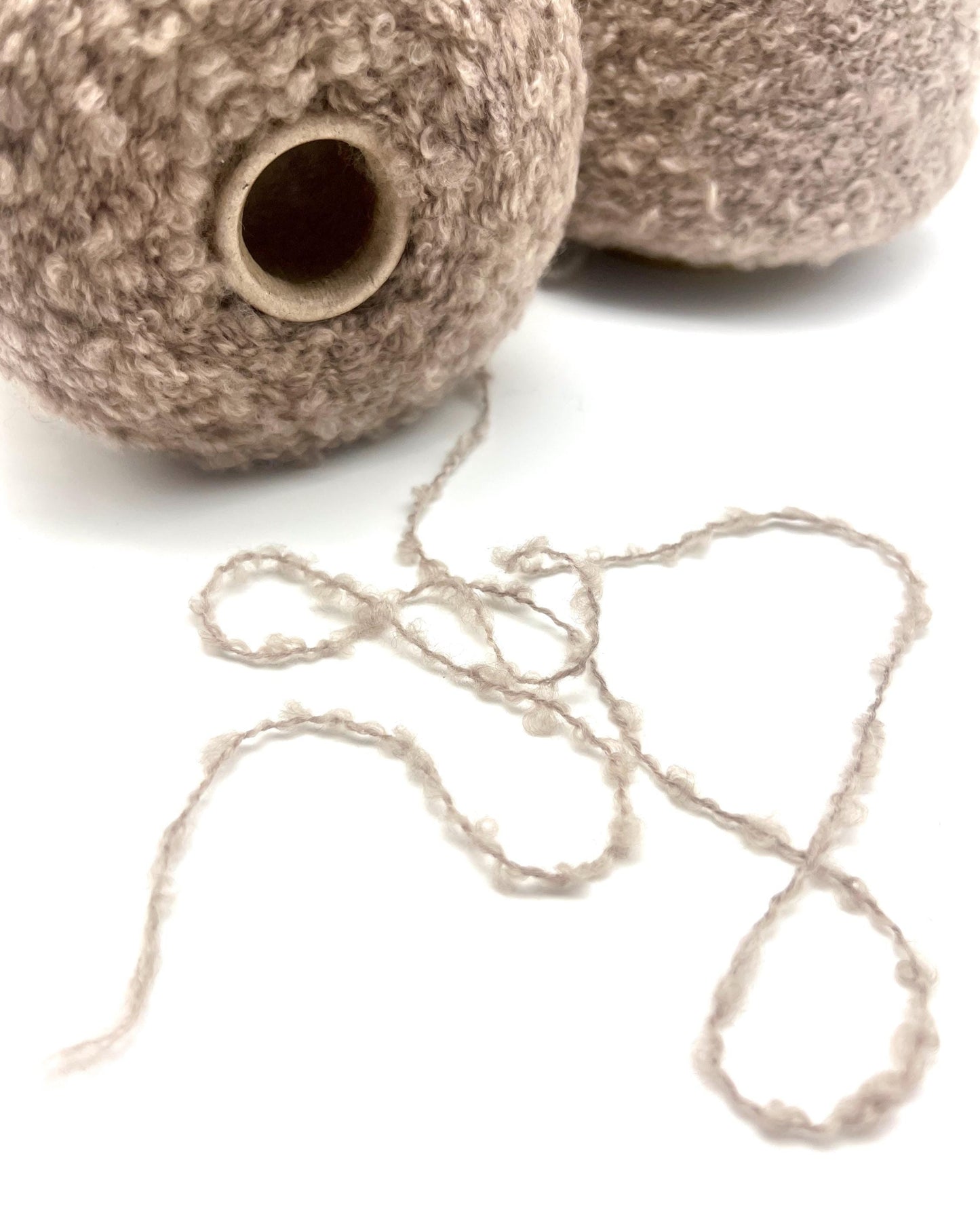 Textured brown ceramic pots with a string of beads on a white background
