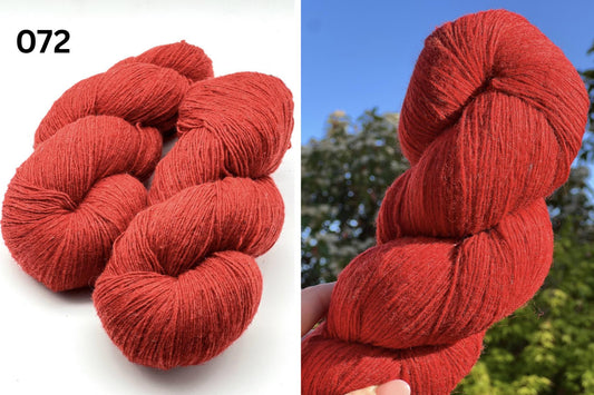 Red yarn skeins with a blurred outdoor background