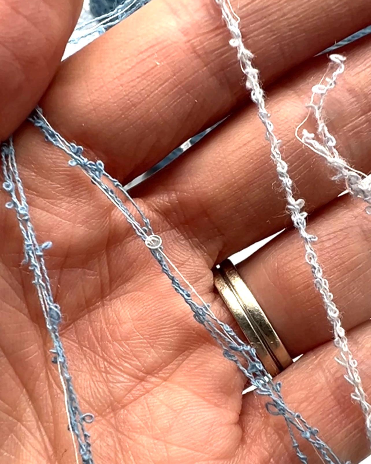 Close-up of a hand holding a delicate silver chain