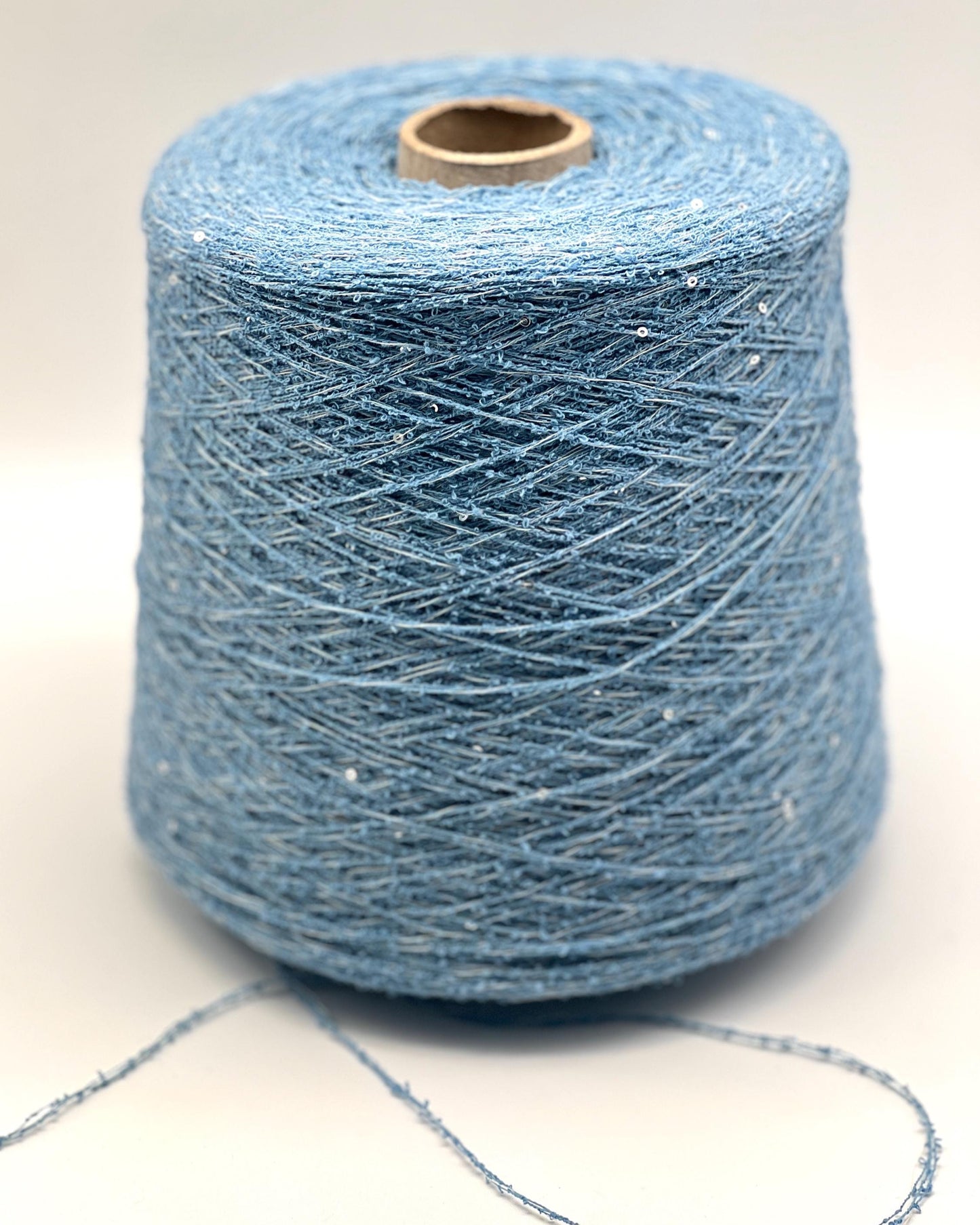 Spool of blue yarn on a white background