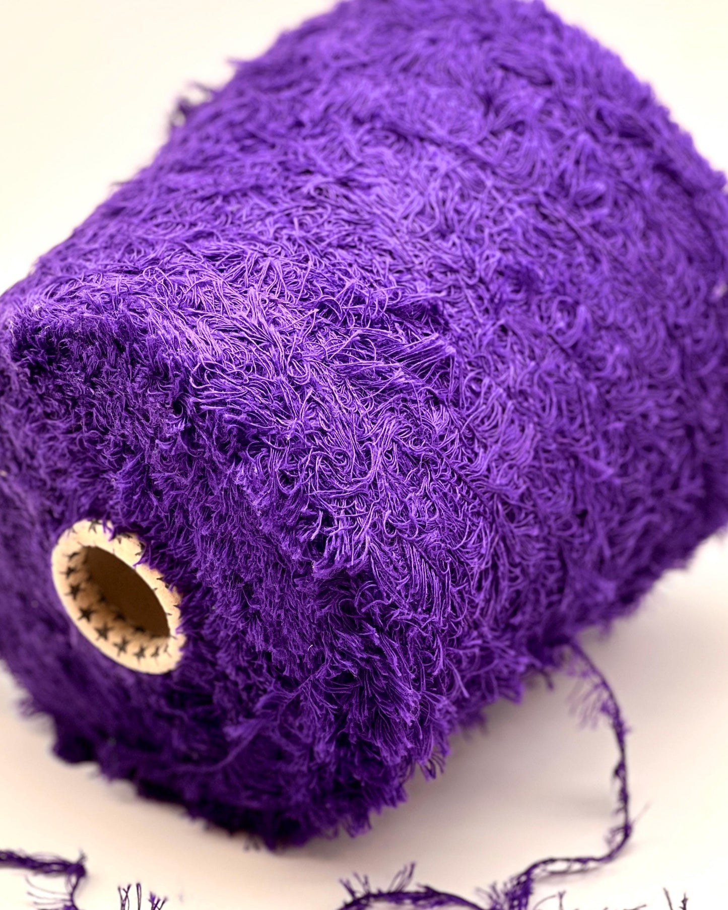 Close-up of a roll of purple lace fabric on a white background
