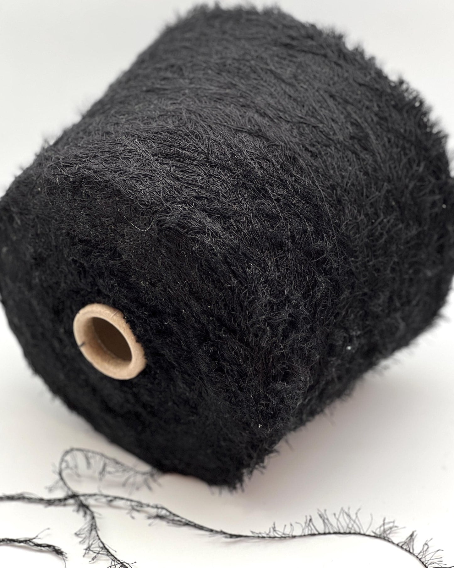Roll of black yarn on a white background
