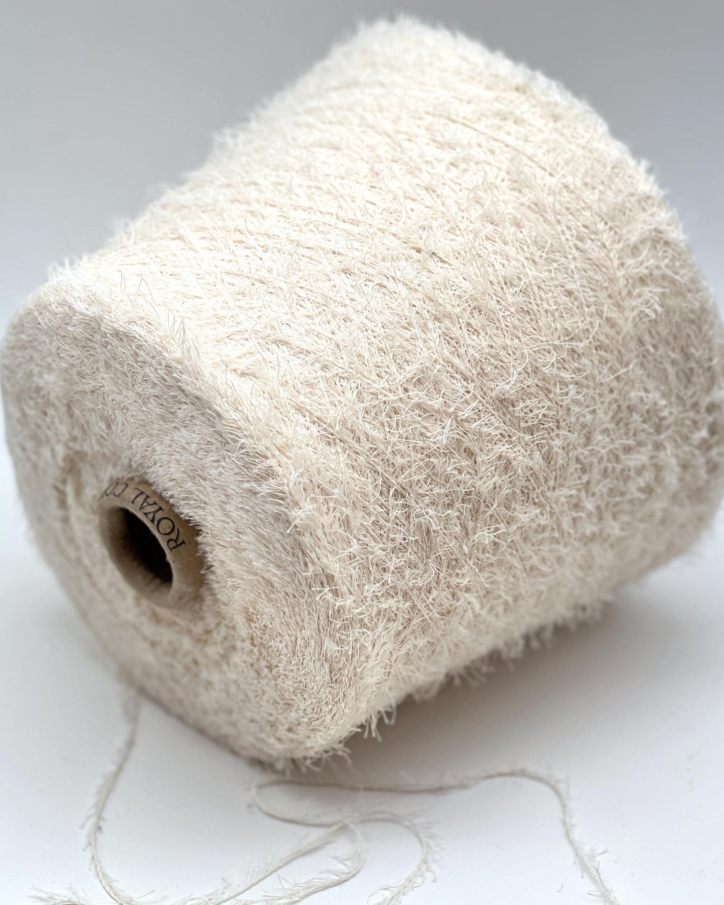 Roll of beige yarn on a white background