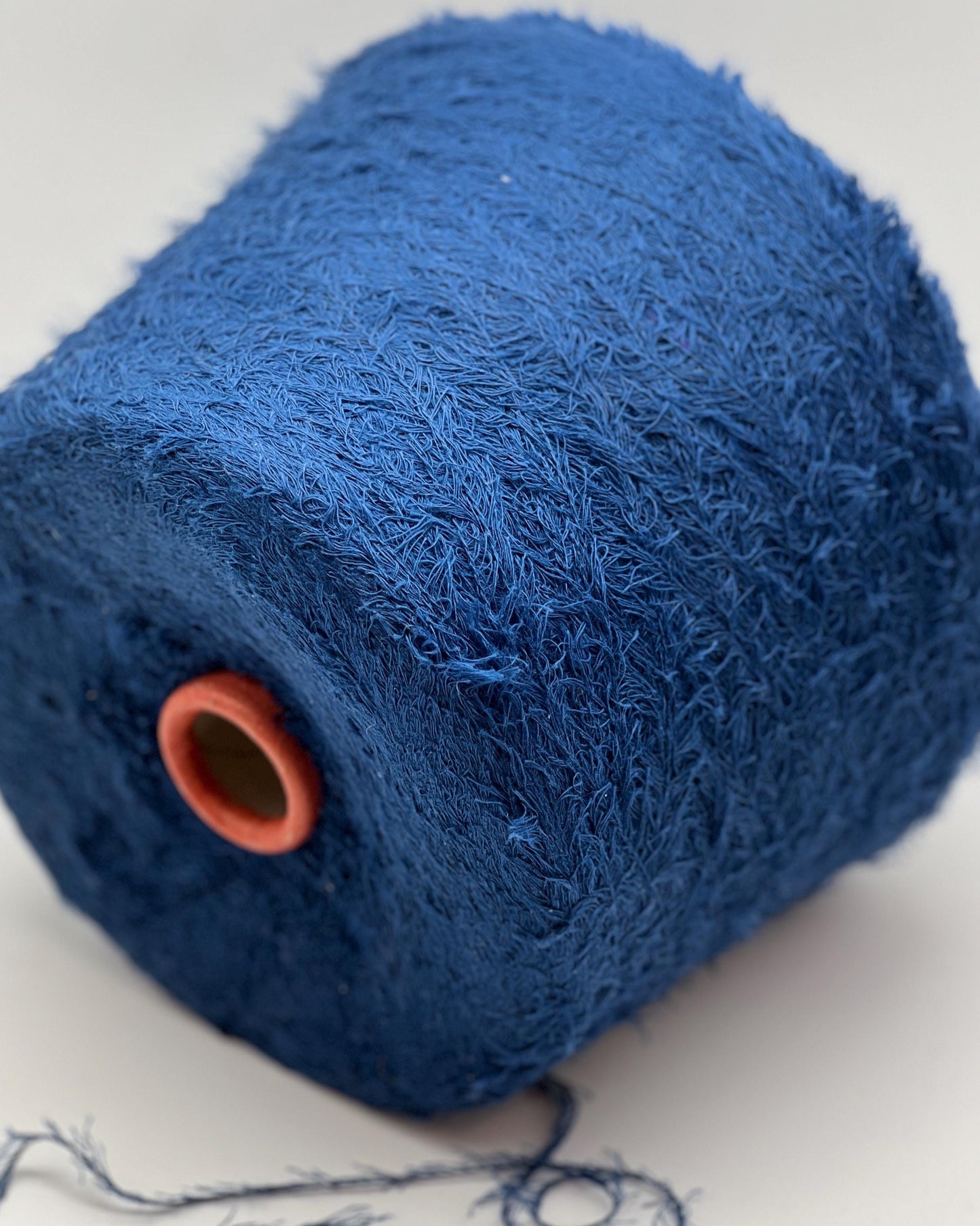 Close-up of a blue textured roll with an orange end on a white background